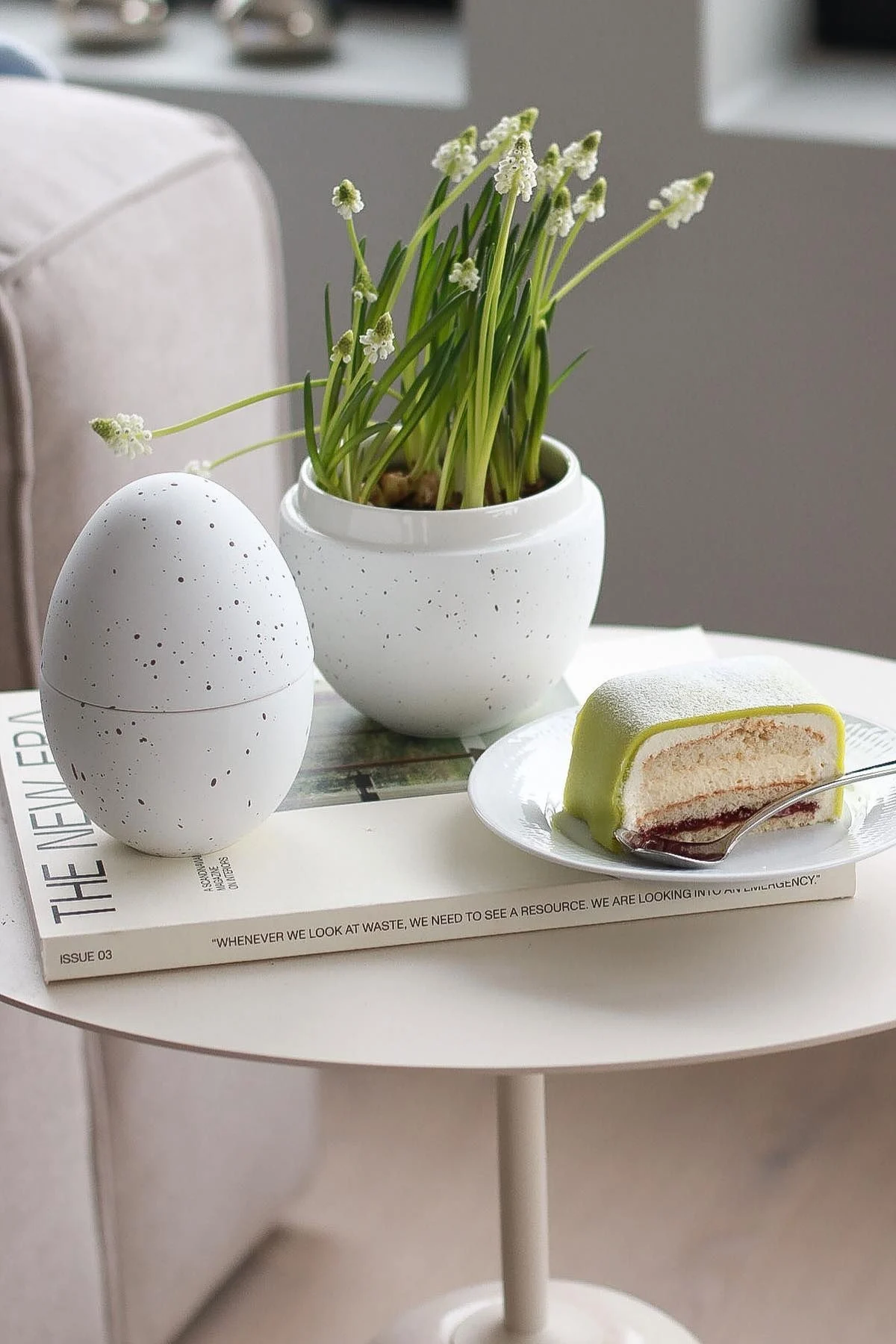 Sur une table d'appoint se trouve la bonbonnière blanche avec des fleurs de Cooee Design, à côté de laquelle se trouve une assiette avec Princesstarta, dans la maison de @picsbyellen.