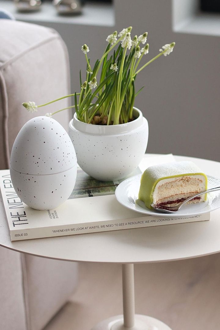 Sur une table d'appoint se trouve la bonbonnière blanche avec des fleurs de Cooee Design, à côté de laquelle se trouve une assiette avec Princesstarta, dans la maison de @picsbyellen.