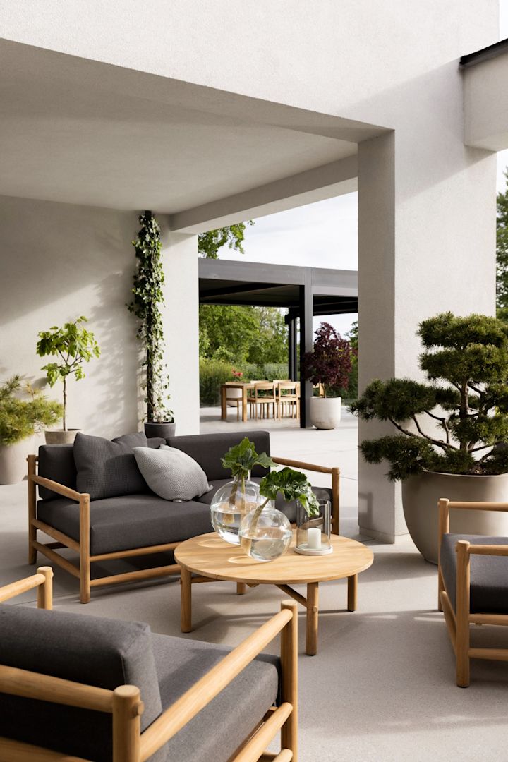 Les meubles de jardin en teck sont absolument à la mode en 2025 - vous voyez ici un groupe de sièges sur une terrasse, composé de la collection Saltholm de Skargaarden.