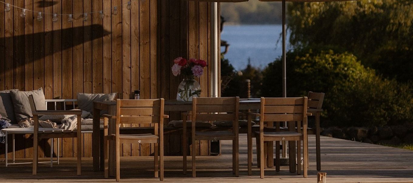 Un coin repas confortable sur un patio en bois.
