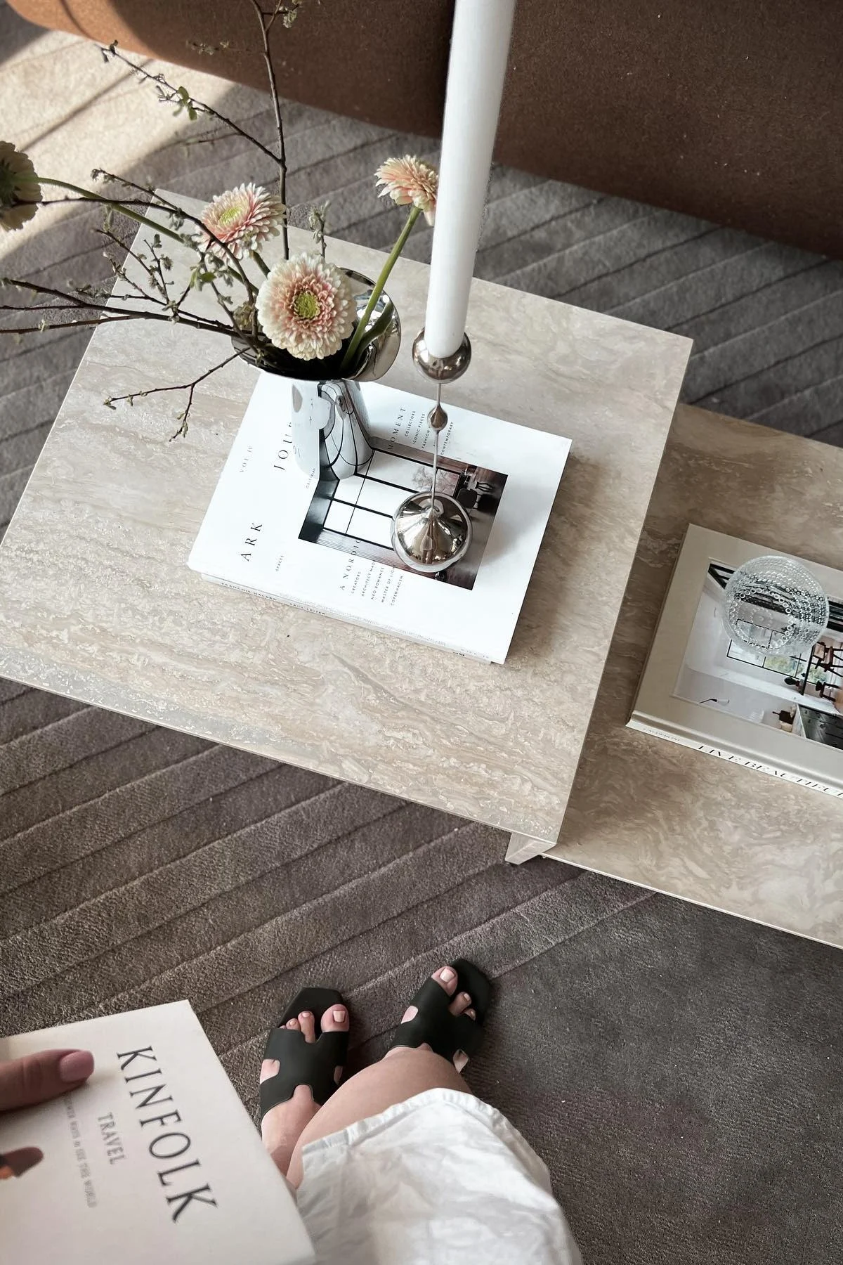 La table d'appoint Distinct de Ferm Living est décorée d'un livre, du bougeoir Tender de Klong et du vase Bloom Botanica avec des fleurs fraîches.