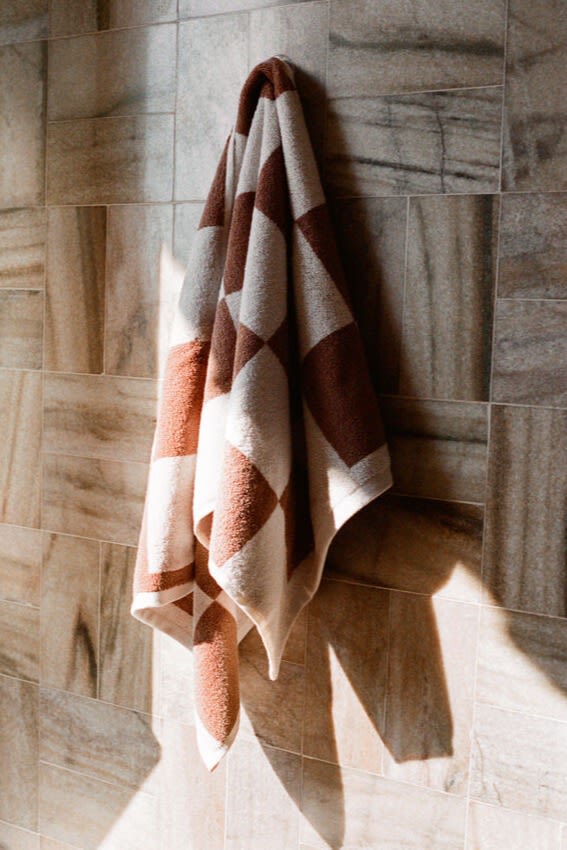 Pantone désigne la mousse moka comme la couleur de l'année 2025. Ici, vous voyez une serviette à carreaux de HAY accrochée au mur dans le même ton de brun. 