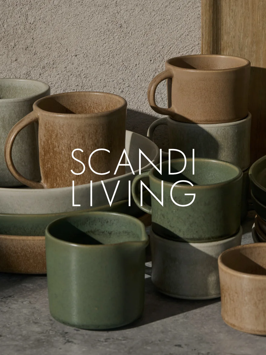Collection de tasses et plats en céramique aux tons terreux, certains empilés, avec texte 'SCANDI LIVING'.