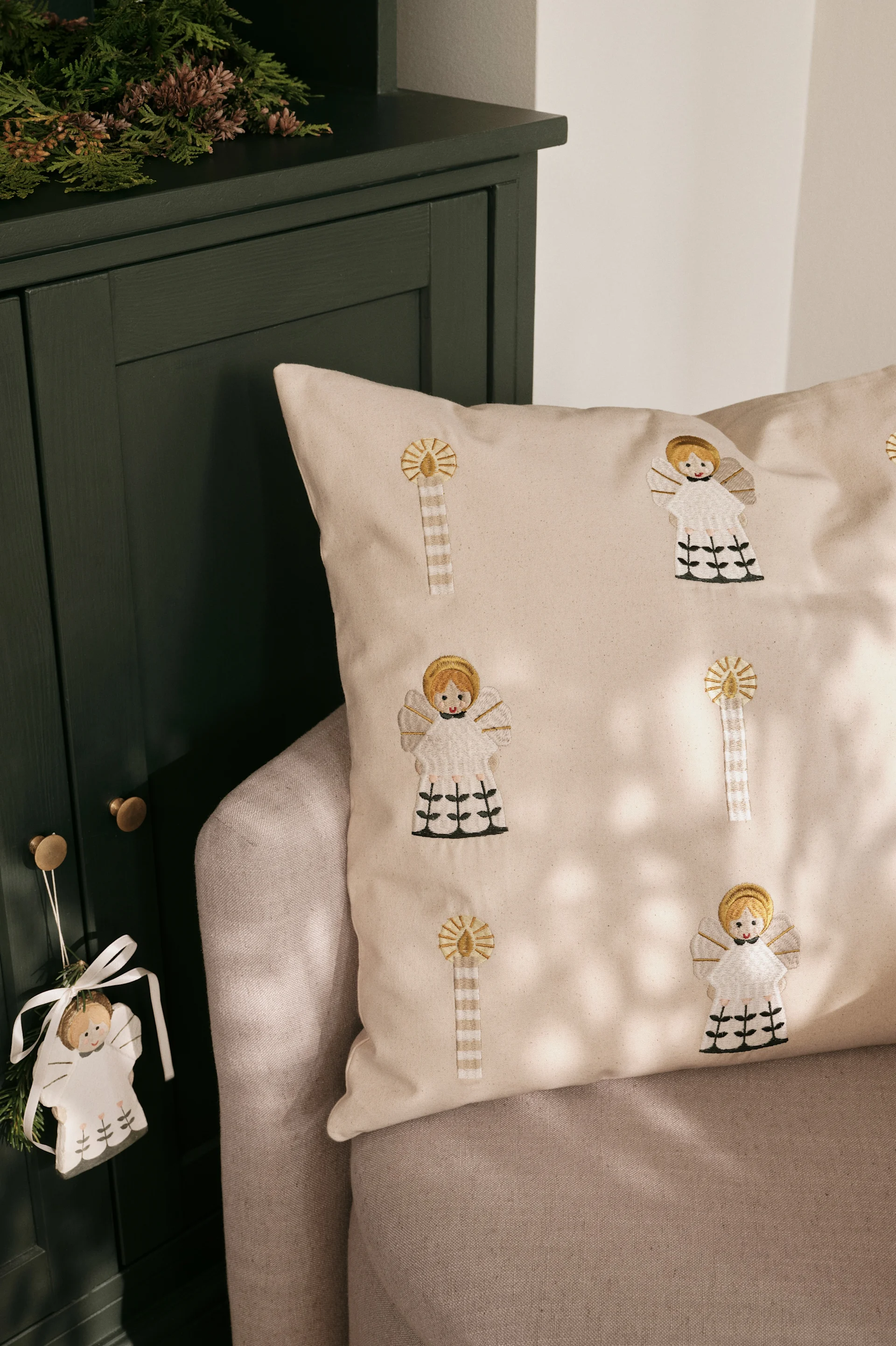 Les coussins de Noël rencontrent également un grand succès en Scandinavie. Ici, le coussin doré Fairy Tale de Broste Copenhagen est posé sur un canapé.