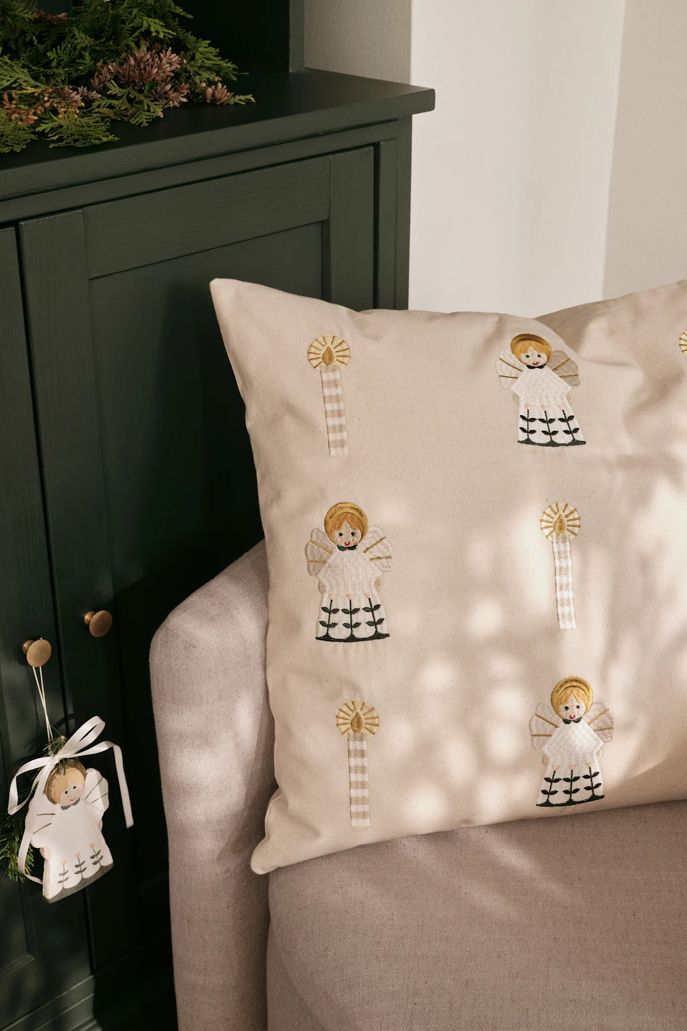 Les coussins de Noël rencontrent également un grand succès en Scandinavie. Ici, le coussin doré Fairy Tale de Broste Copenhagen est posé sur un canapé.