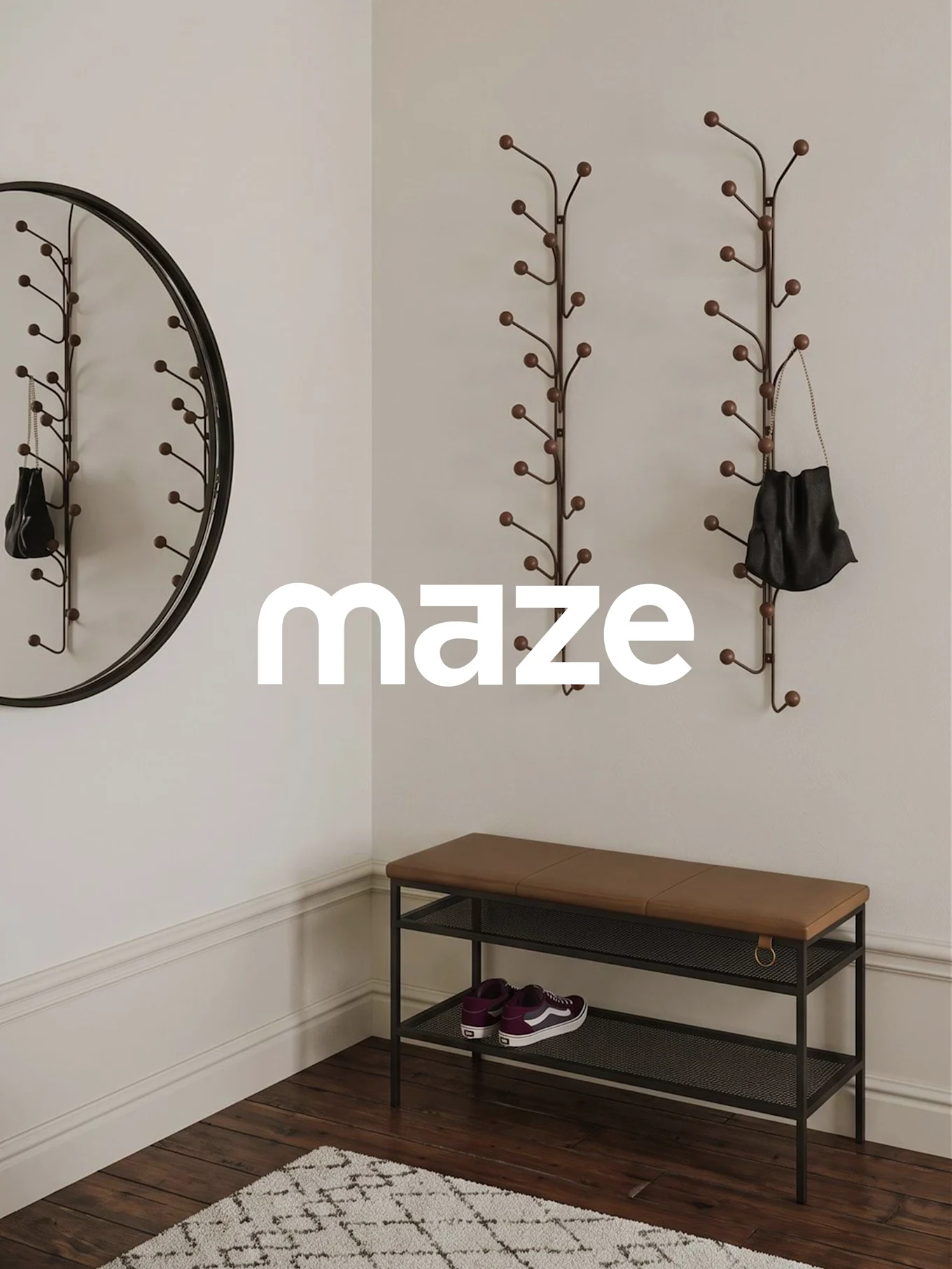 Une entrée avec le logo MAZE. Elle comprend deux porte-manteaux muraux, un miroir rond, un banc avec coussin marron et des baskets.