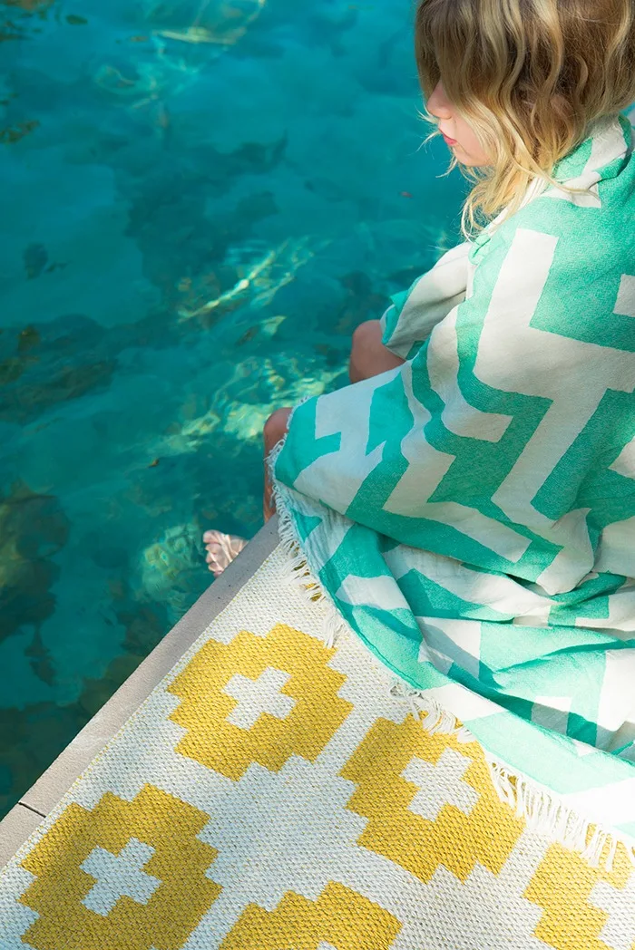 Tapis d'extérieur : le tapis Flower de Brita Sweden ne craint pas l'humidité, vous pouvez donc le placer sans problème à côté de la piscine.