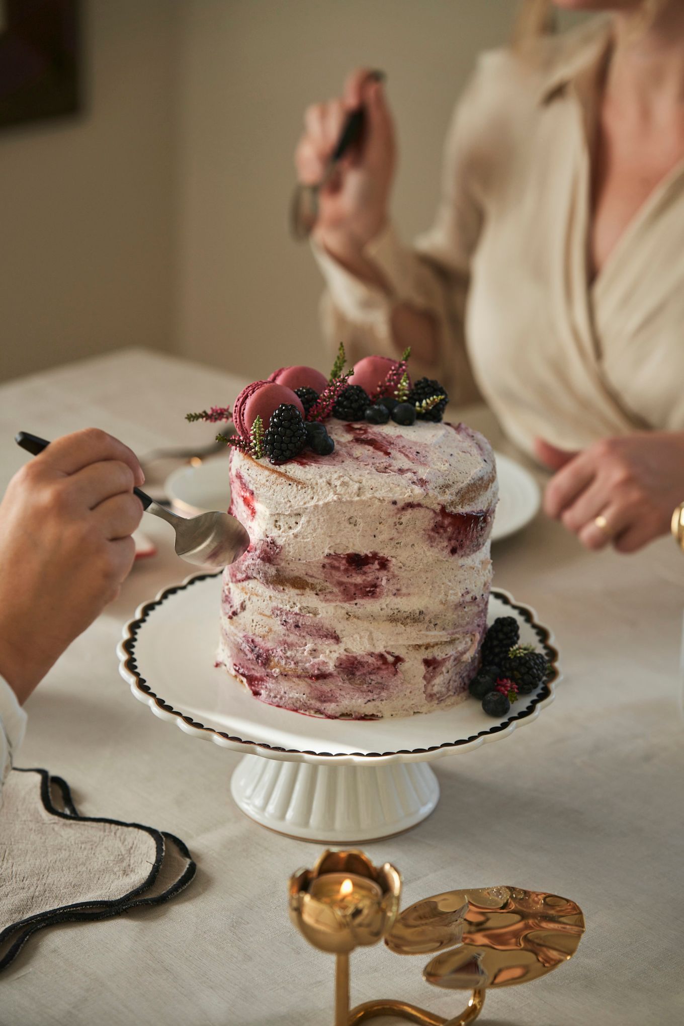 Célébrez la fête de la Galentine en organisant un goûter. Ici, vous voyez un gâteau spécial Galentine avec des baies de saison et des macarons. 