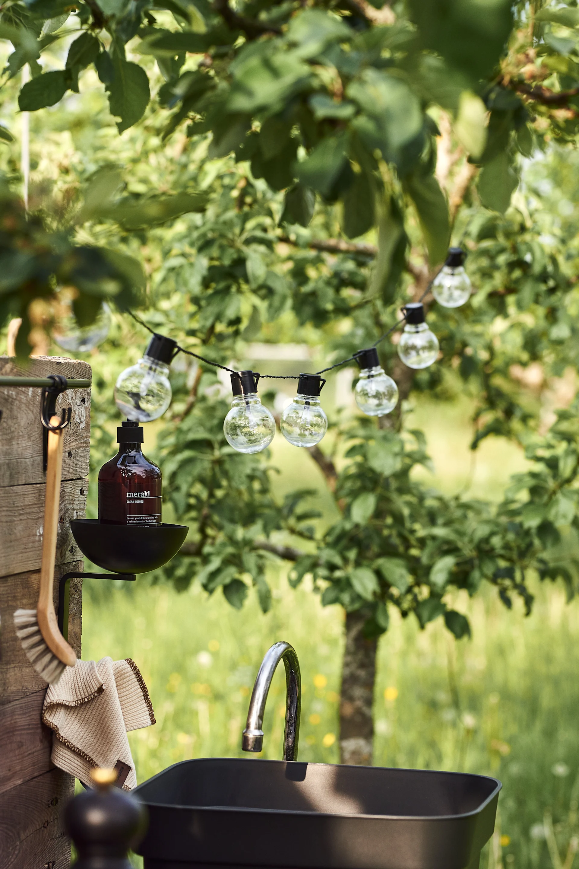 Une guirlande lumineuse apporte une touche chaleureuse à votre cuisine d'extérieur simple et faite maison.