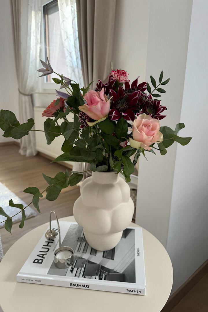 Ici, le petit vase Balloon blanc de Louise Roe est posé avec un bouquet de fleurs sur une table d'appoint dans la maison de @Merve Tengör.