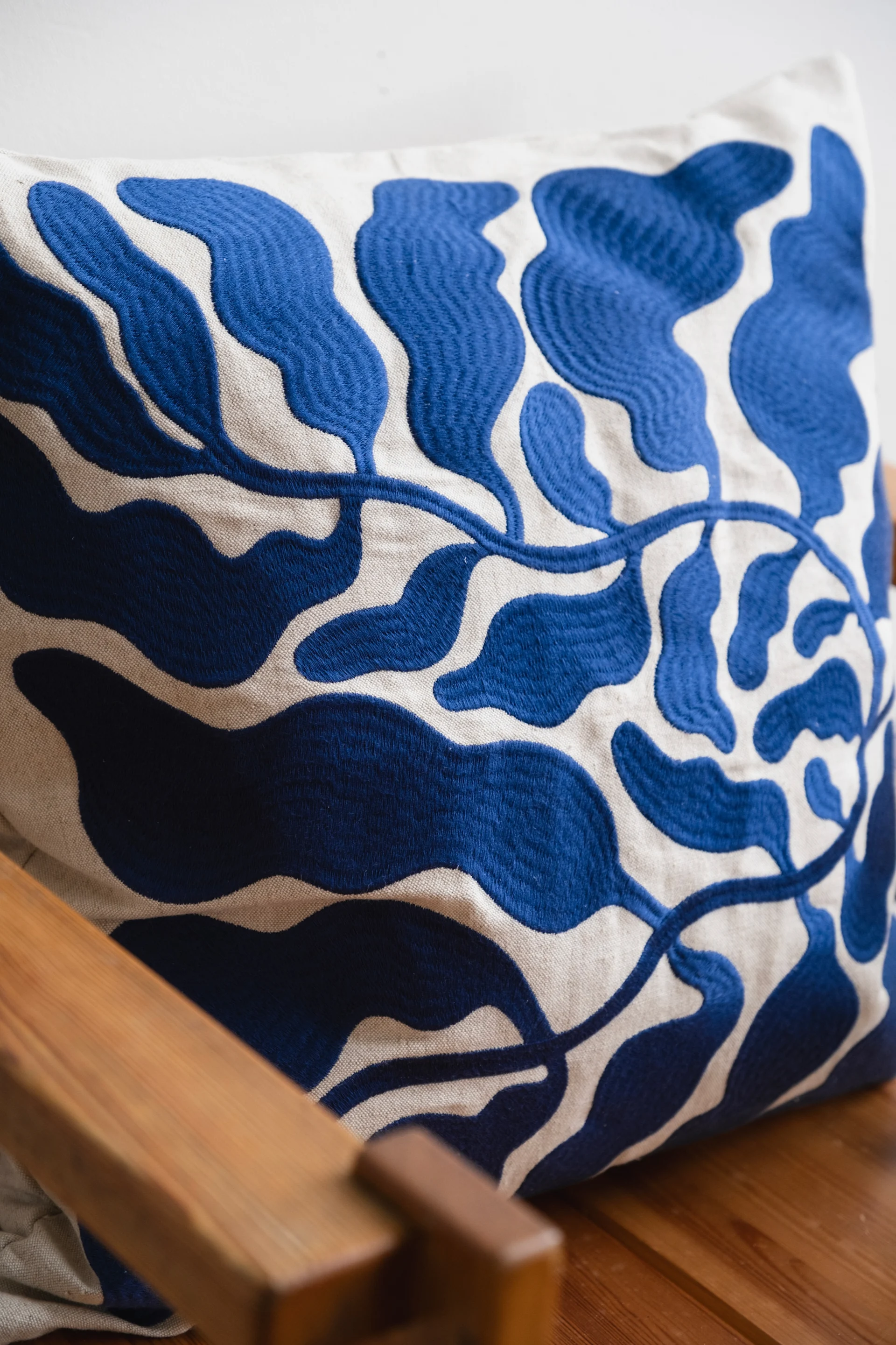 Un coussin à motif floral bleu qui reflète les tendances déco 2026.