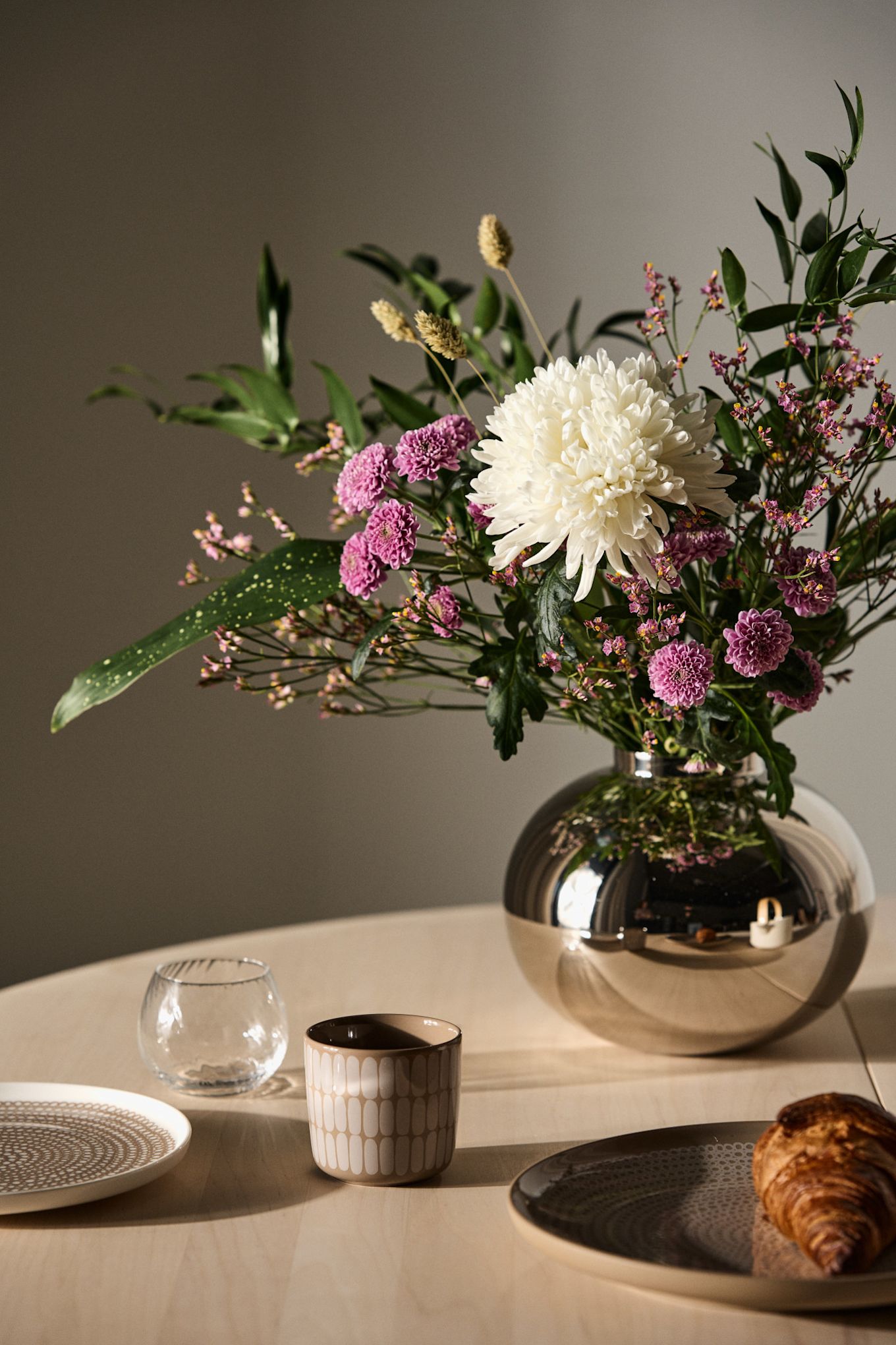 Les cadeaux de la fête des mères doivent idéalement exprimer ce que votre mère représente pour vous. Offrez-lui un bouquet de fleurs blanches et roses avec un vase assorti, ici le vase argenté Amico de Hilke.