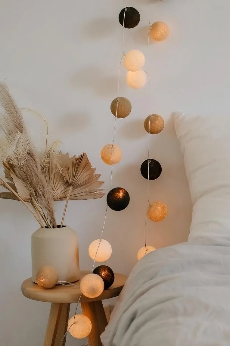 Avec ses tons beiges et bruns, la guirlande lumineuse Biscotti d'Irislights, suspendue ici à côté d'un lit, est la décoration bohème parfaite.