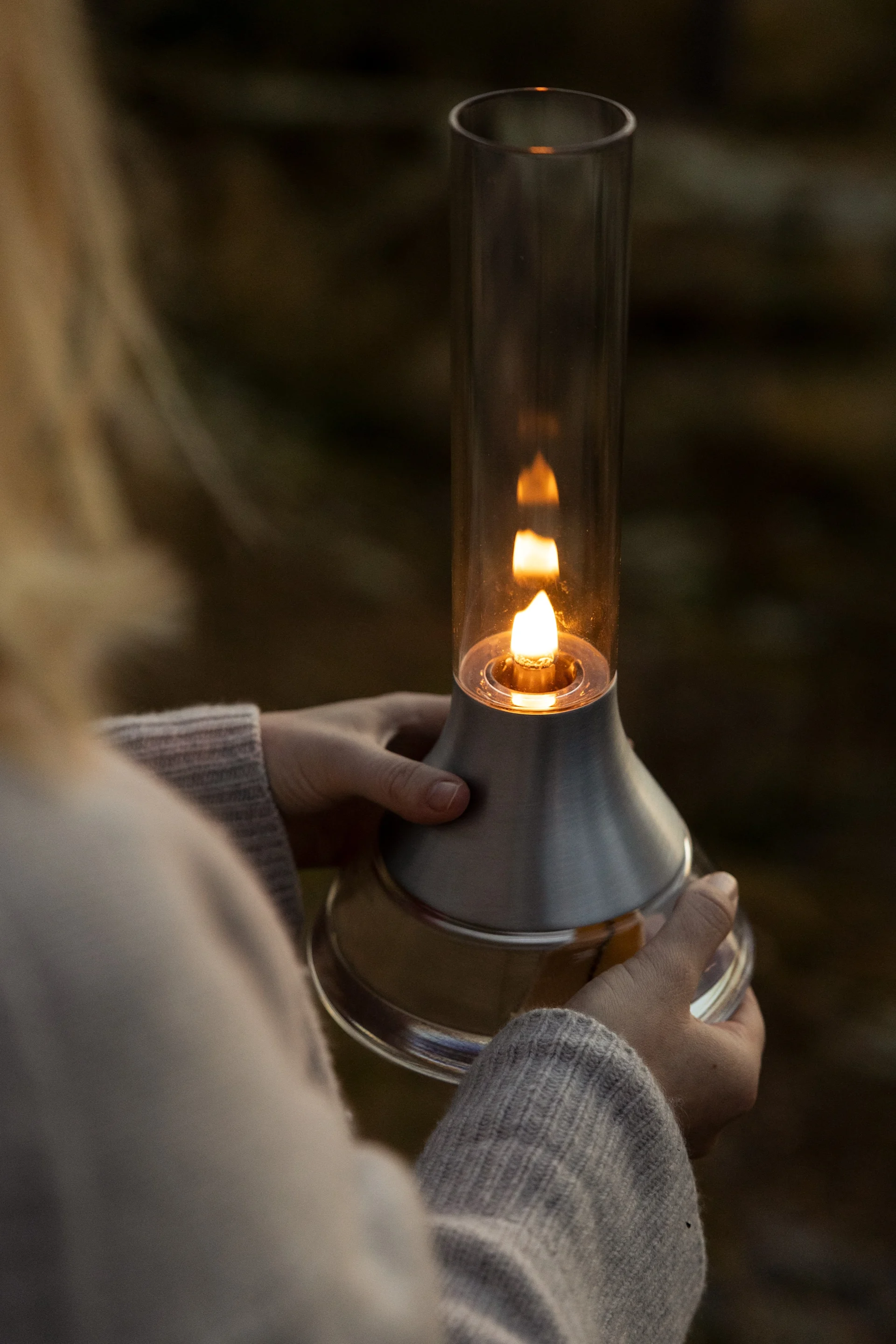 Le lagom au fil des saisons : une femme tient à la main la lampe à pétrole Fyr de Design House Stockholm.