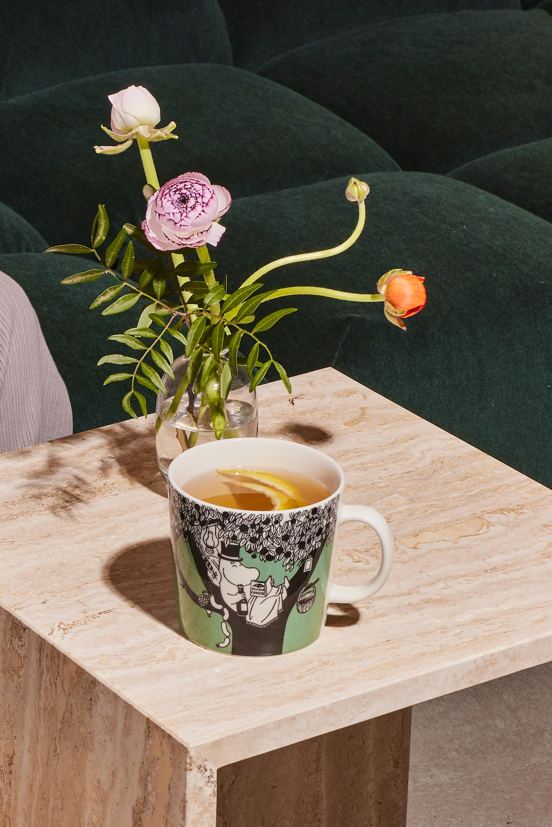 La tasse verte de Moomin est posée sur une table basse avec du café.
