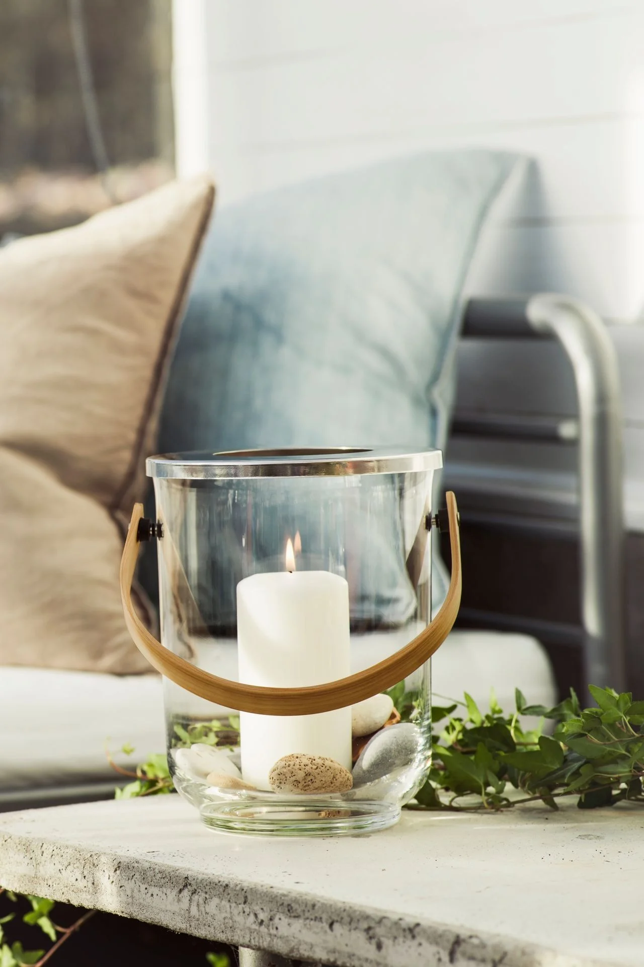 Illuminez votre table d'extérieur avec des lanternes et des photophores d'extérieur, par exemple avec la lanterne Nature avec anse de Sagaform !