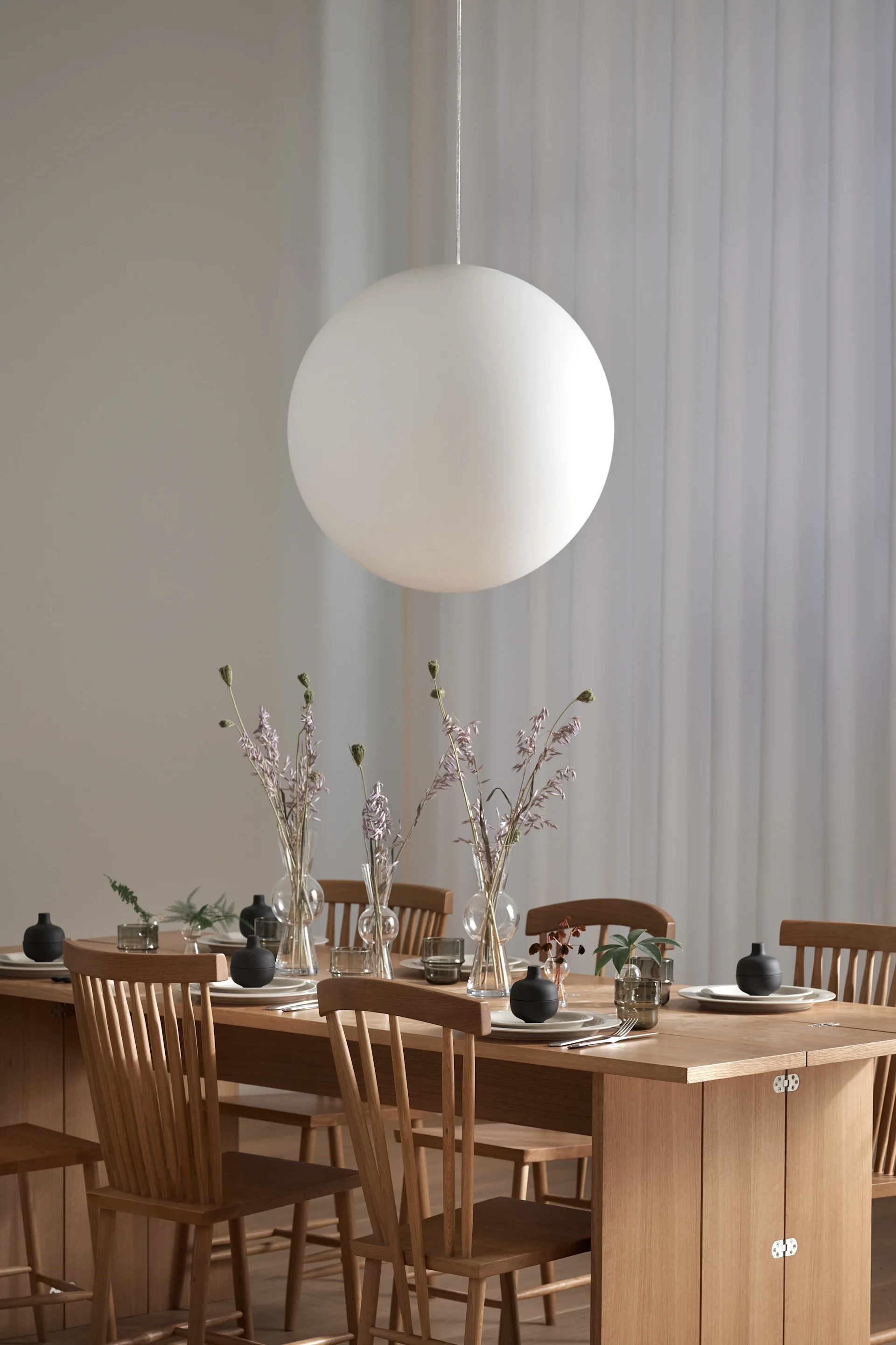 La lampe Luna de Design House Stockholm suspendue au-dessus de la table à manger.