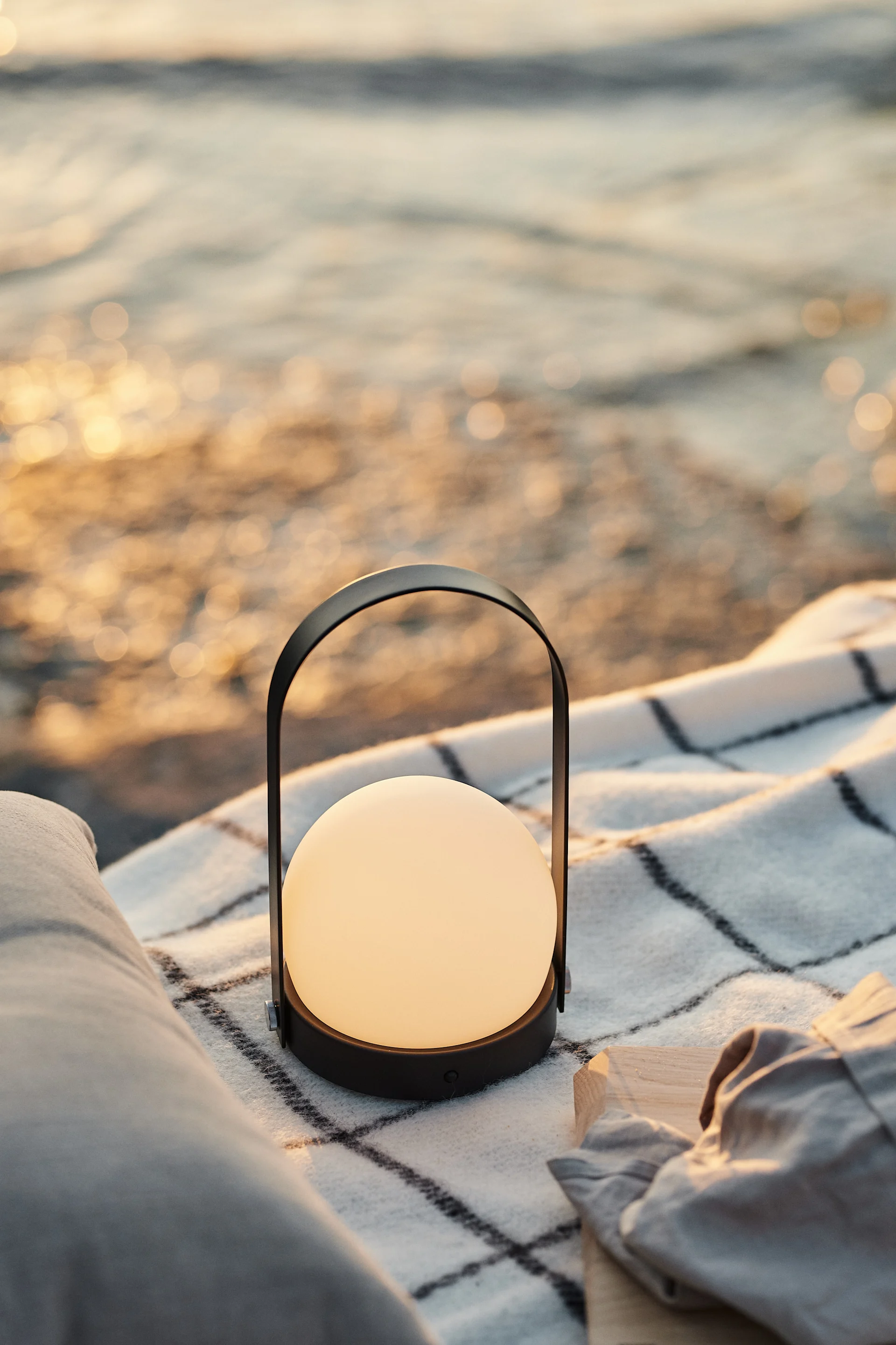 Cette lampe portable de Menu, que vous pouvez disposer sur votre couverture de pique-nique à la plage au coucher du soleil pour créer une ambiance détendue.
