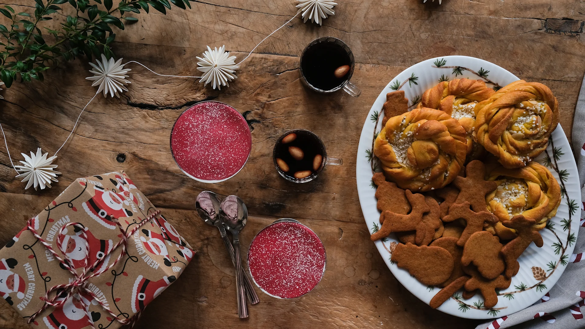 Le grand plateau de service de Kähler rempli de biscuits de Noël est posé sur une table, à côté du vin chaud, des verres de gâteau princesse et des cadeaux.