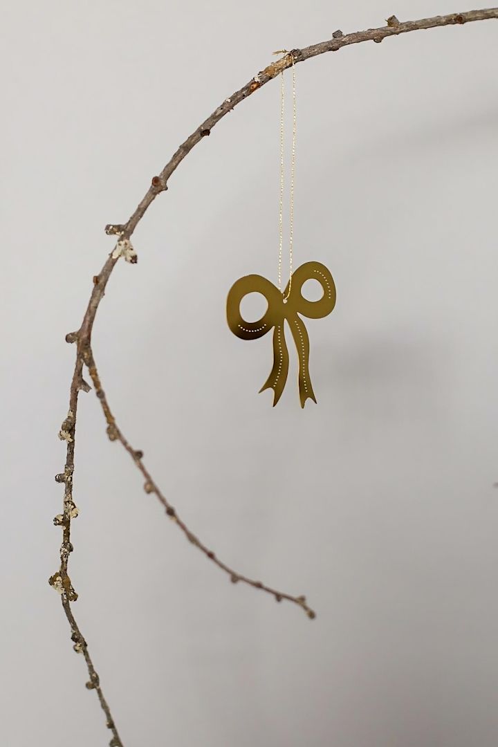 Décorations de Noël 2025 : le pendentif décoratif doré Missia de Lene Bjerre est accroché au mur.