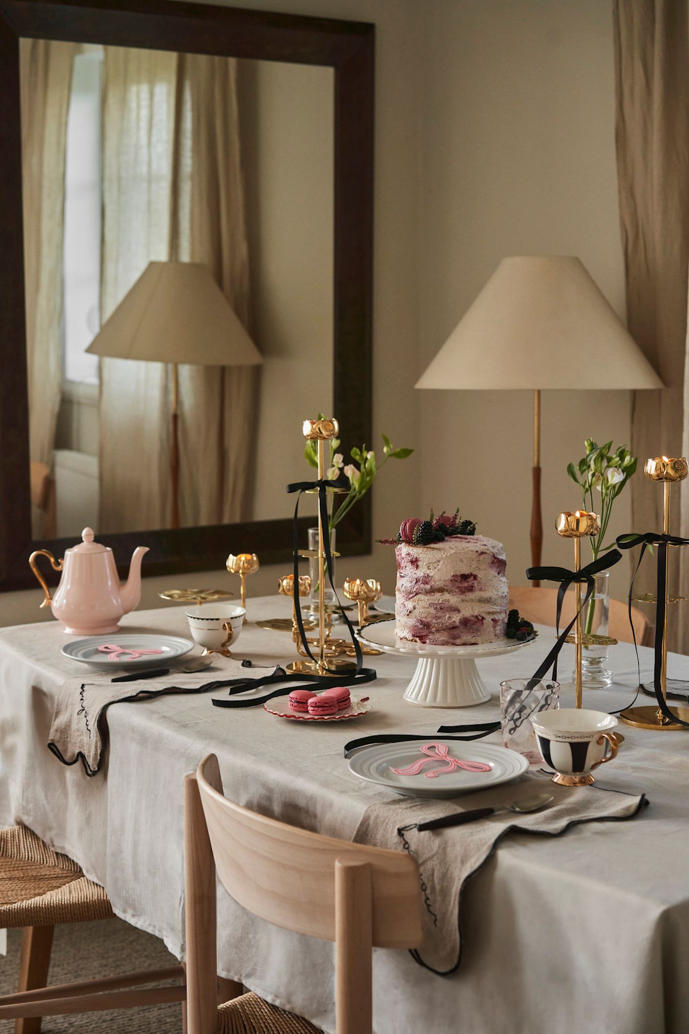 Célébrez la Journée de la Galentine en organisant un goûter à la maison avec vos amies préférées. Ici, vous voyez un service de table rose et or avec des accents noirs de Hilke Collection.  