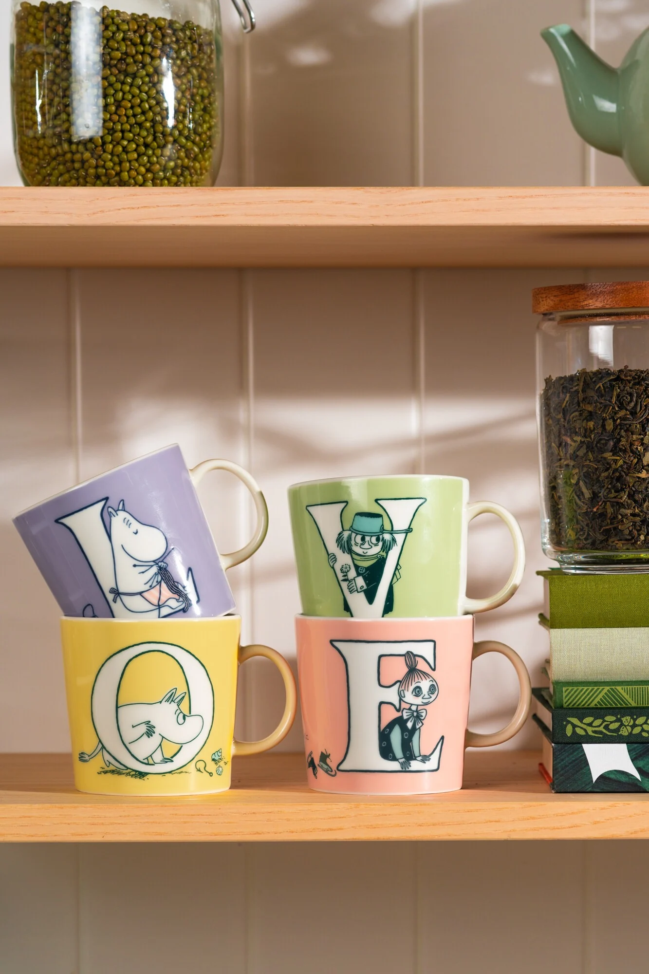 Quatre tasses Moomin de la collection ABC sont posées sur un buffet et forment le mot « Love ».