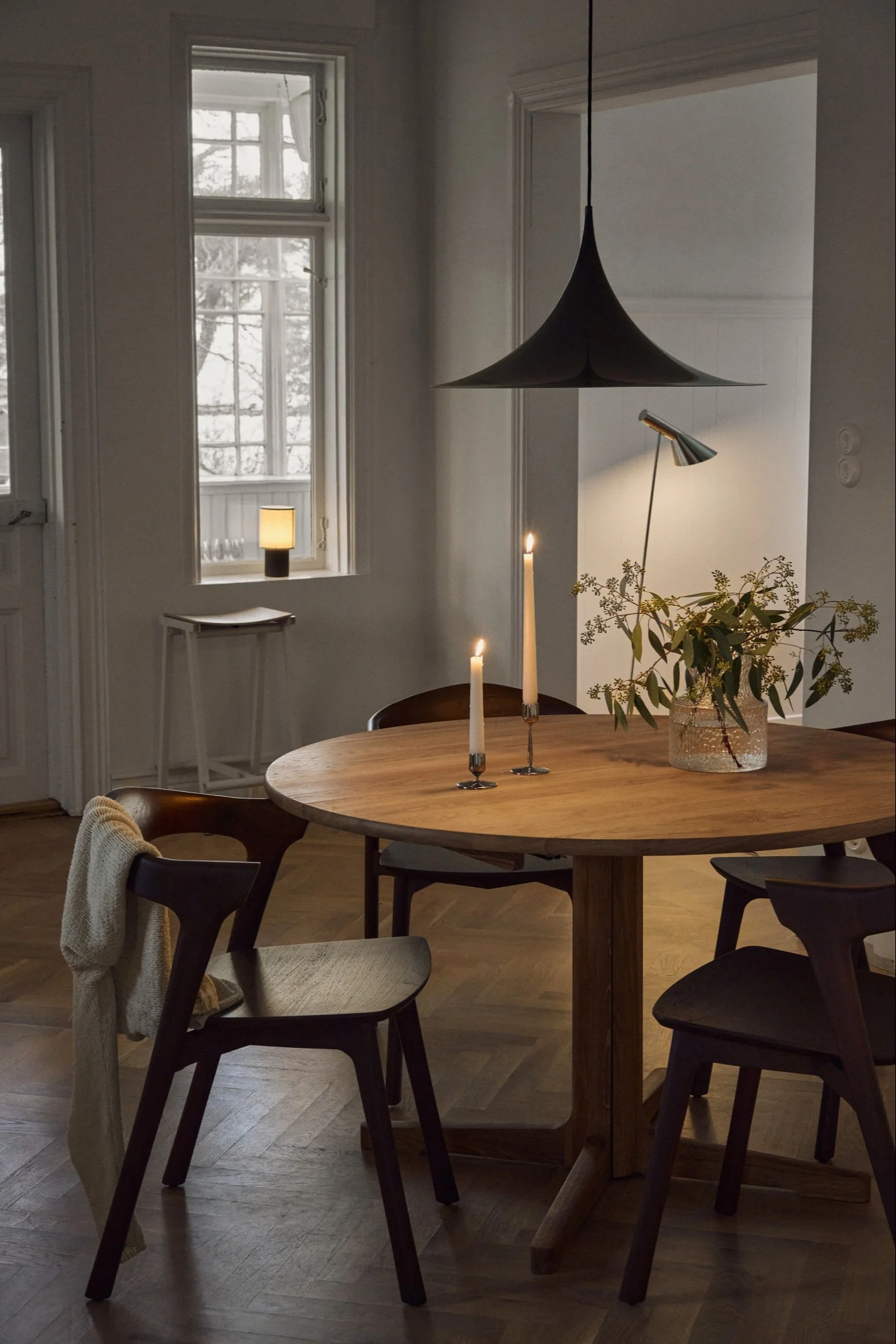 Lampes scandinaves : la suspension Semi de Gubi est suspendue au-dessus d'une table dans une salle à manger décorée dans un style scandinave.