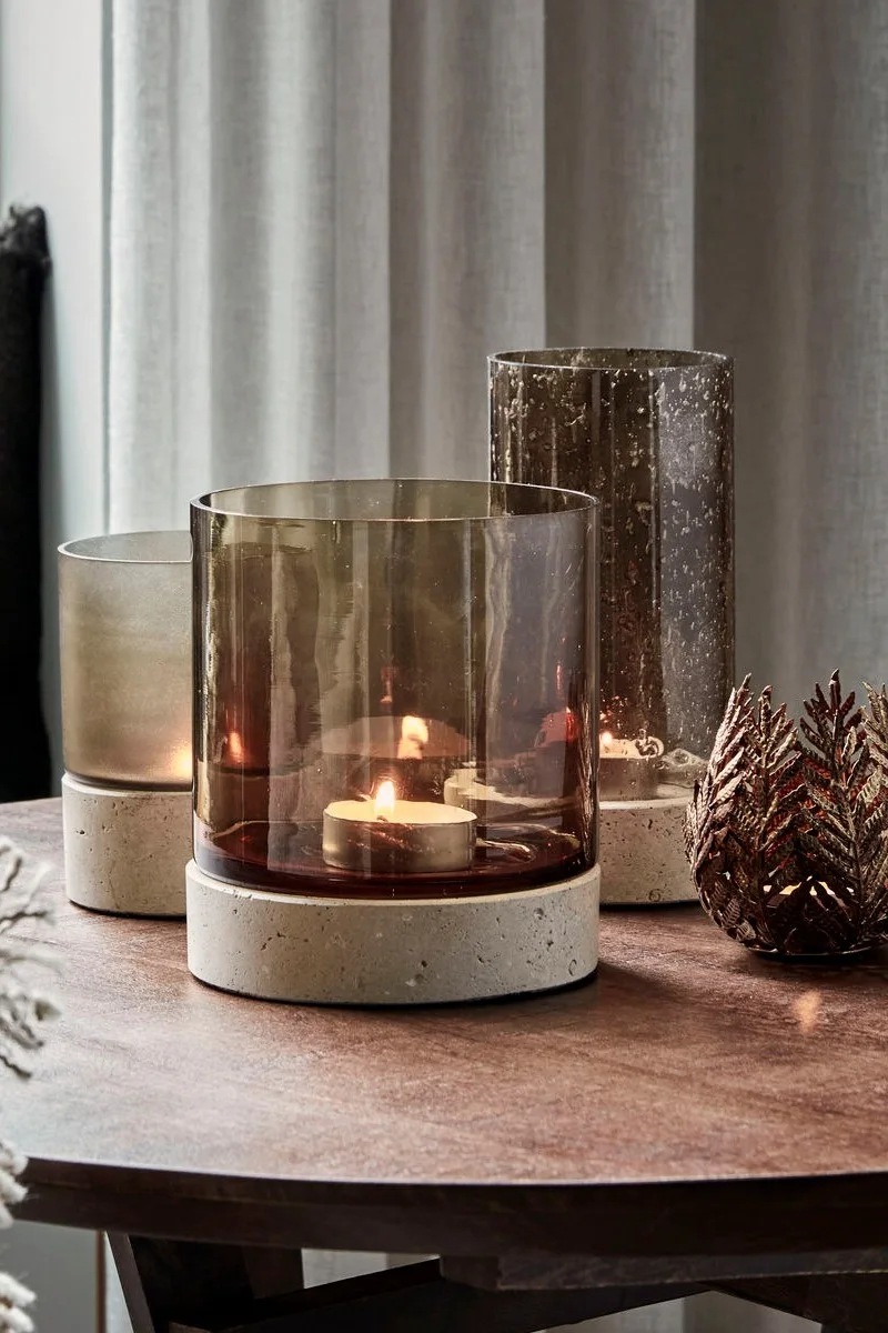 Une table basse est décorée dans un style automnal avec trois bougeoirs Rivo de House Doctor de différentes tailles.