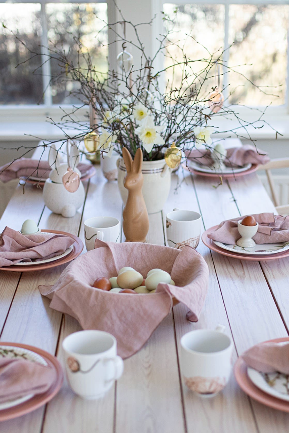 Voici une idée de table de Pâques de l'influenceuse suédoise @colorelles avec des tons de rose pastel et un arbre de Pâques. 
