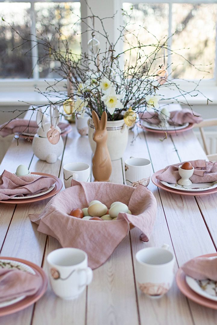 Voici une idée de table de Pâques de l'influenceuse suédoise @colorelles avec des tons de rose pastel et un arbre de Pâques. 
