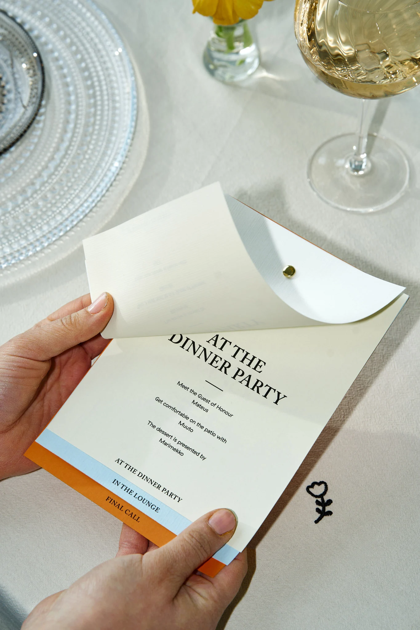 Découvrez comment organiser une fête : ici, vous voyez une paire de mains tenant une carte mettant en avant le programme de la soirée.