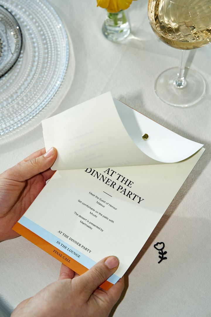 Découvrez comment organiser une fête : ici, vous voyez une paire de mains tenant une carte mettant en avant le programme de la soirée.