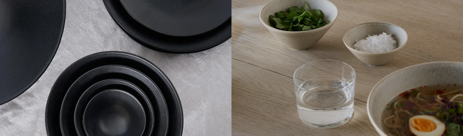 Assiettes et bols noirs sur tissu gris; bol de ramen avec œuf, coriandre, sel et eau sur une table en bois.