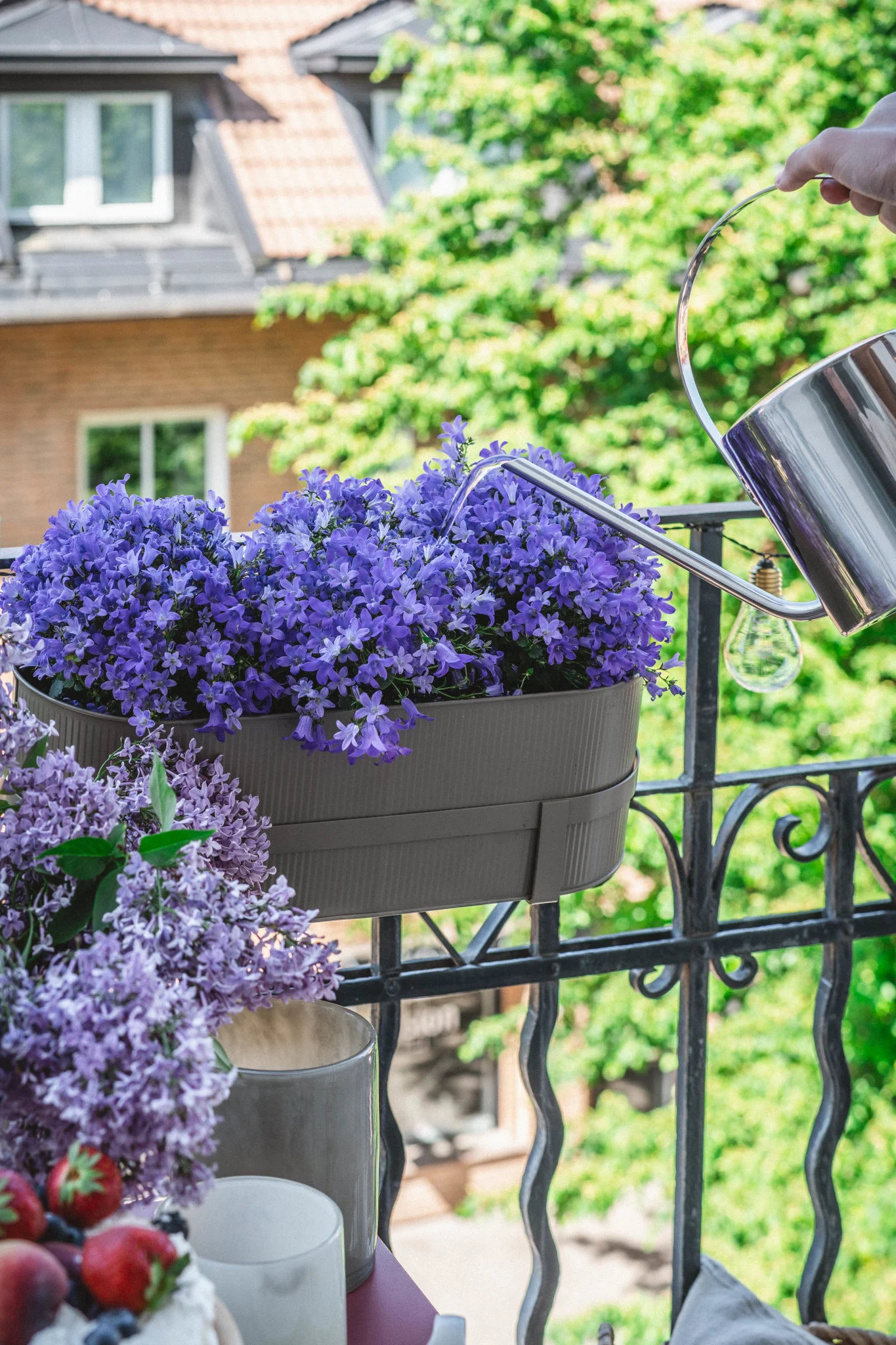 Ici, vous pouvez voir le pot de fleurs Bau en beige de Ferm Living sur la balustrade d'un balcon.