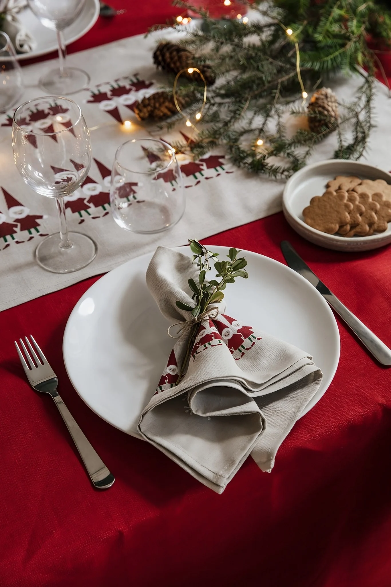 Pour une décoration de Noël scandinave parfaite, il faut aussi des textiles assortis. Ici, vous voyez une table de Noël dressée avec une nappe et des serviettes de la collection Tomtenisse d'Almedahls.