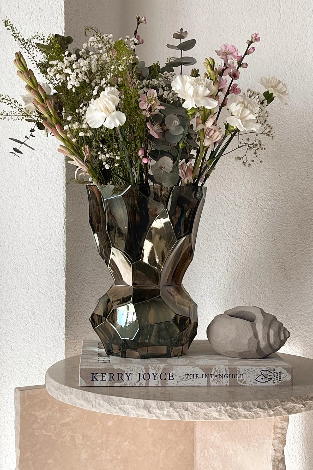 Sur la table d'appoint de @miia_home_interior se trouve le grand vase Reflection de Hein Studio, orné d'un bouquet printanier.