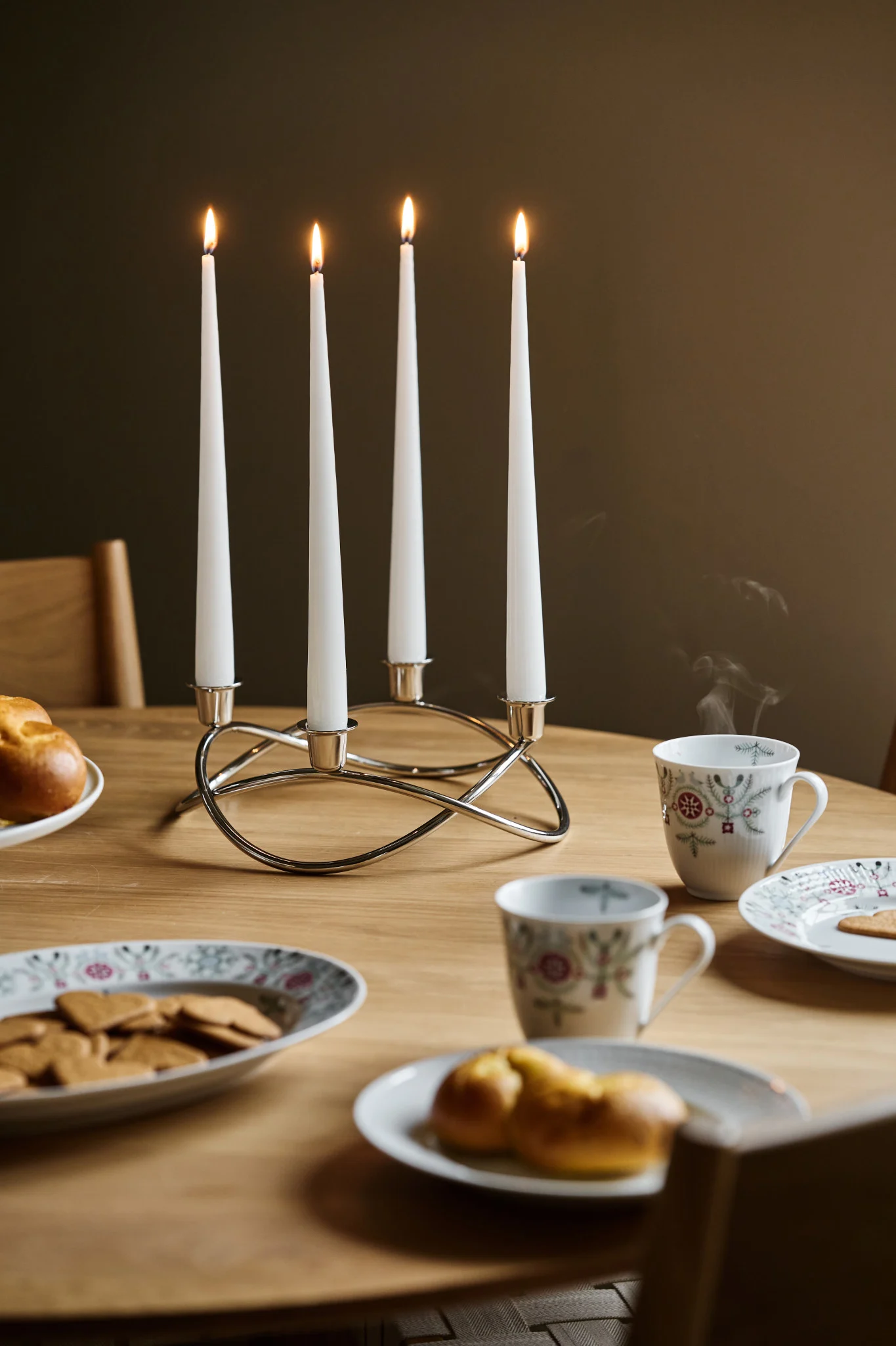 Une déco sympa, c'est aussi important pour un glöggmingel : ici, tu peux voir le bougeoir Season de Georg Jensen sur une table, avec à côté de la vaisselle de Noël avec des pains d'épices et des biscuits au safran.