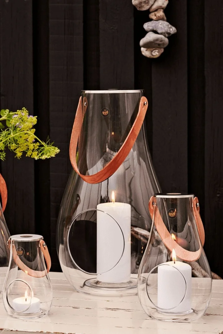 Disposez de préférence les lanternes et photophores d’extérieur en groupes. Ici, vous voyez la lanterne Design with Light de Holmegaard en différentes tailles.