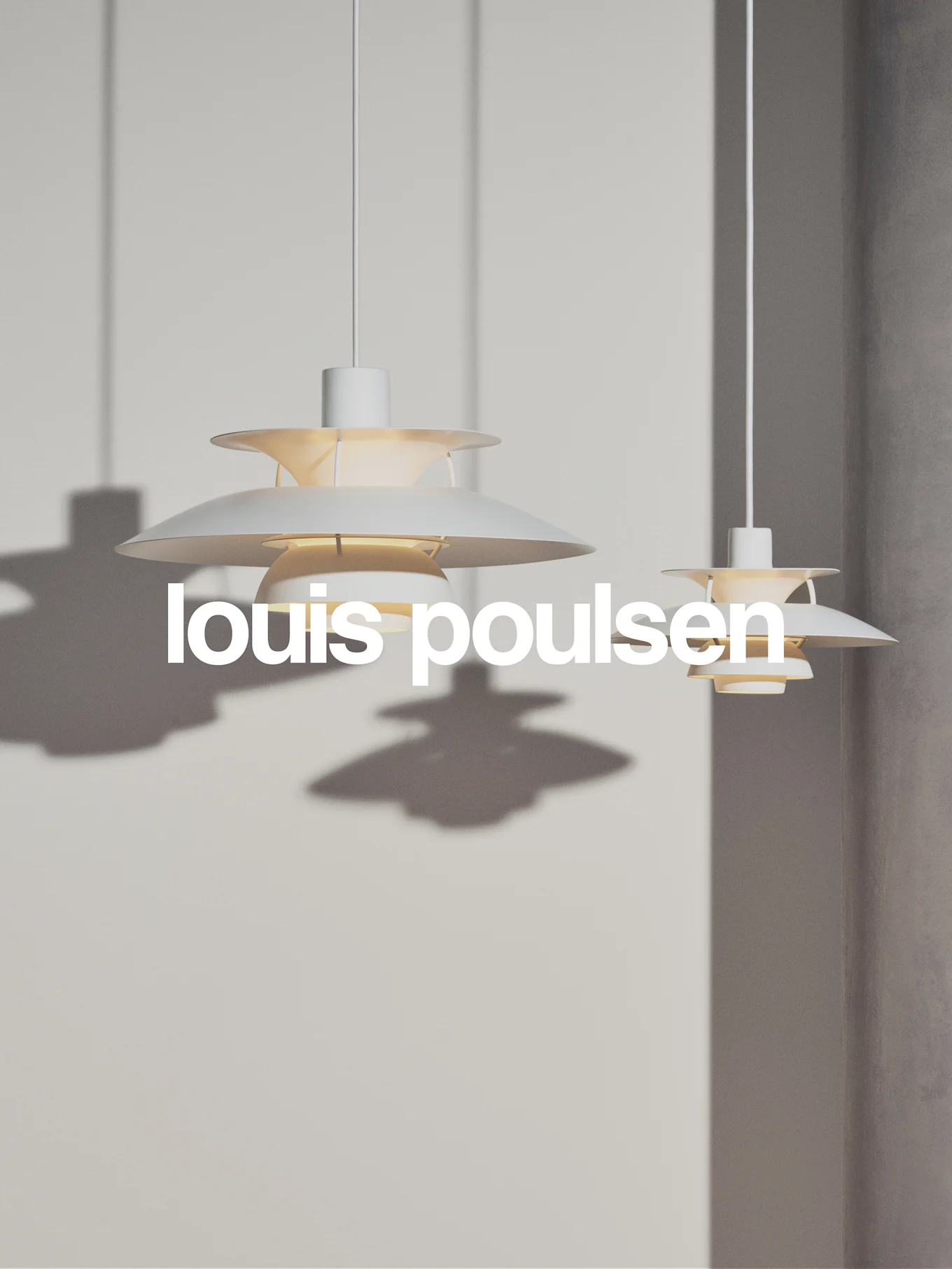 Deux suspensions blanches à niveaux superposés pendent contre un mur gris clair, avec le texte 'louis poulsen'.