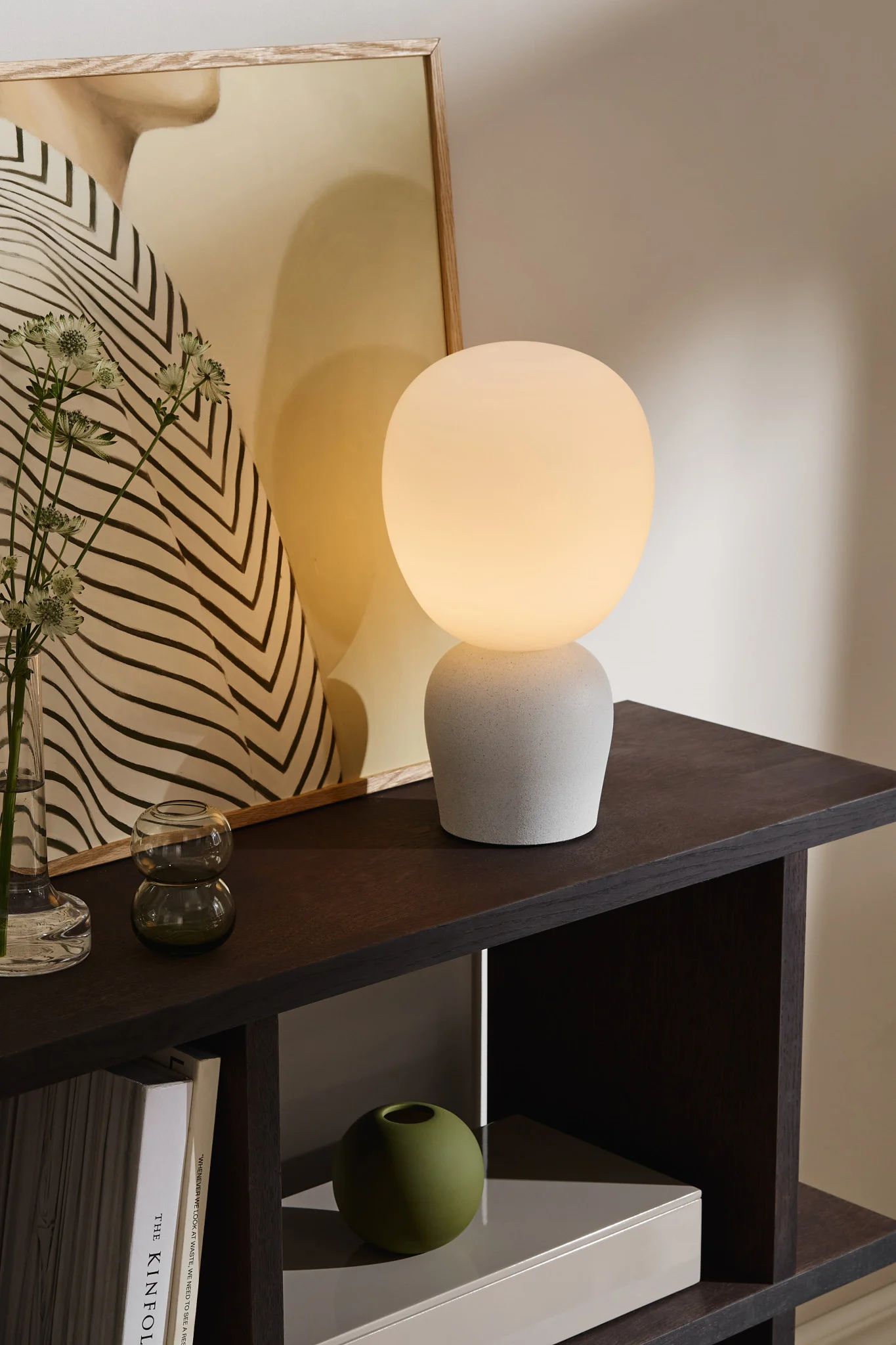 Utilisez différentes lampes, notamment des lampes de table, des appliques et des plafonniers, pour éclairer votre salle à manger. Ici, vous voyez la lampe de table Buddy avec un abat-jour en verre dépoli de Belid. 