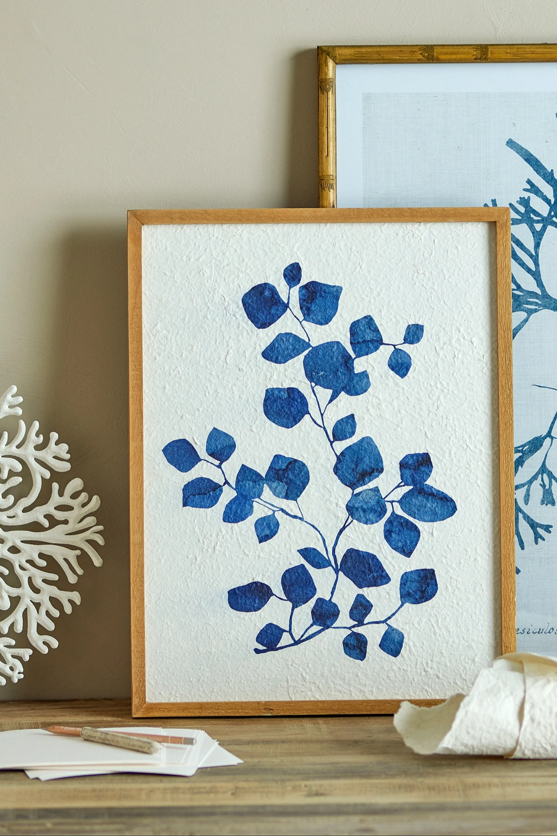 Le tableau Gunnvor bleu dans un cadre en bois de Bloomingville est posé sur une commode et constitue la décoration bohème parfaite.