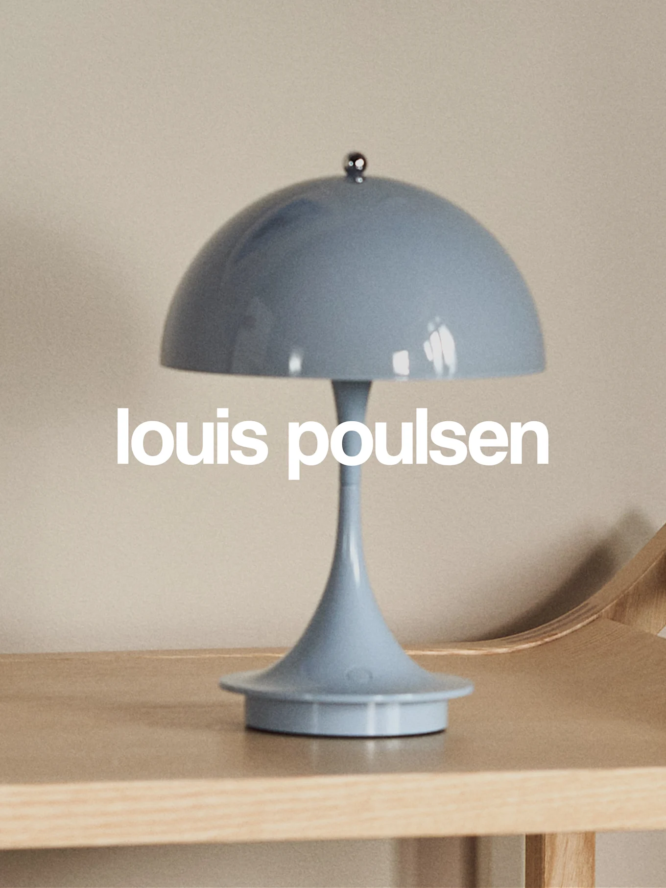 Lampe de table bleu clair en forme de champignon sur une surface en bois avec le texte 'louis poulsen'.