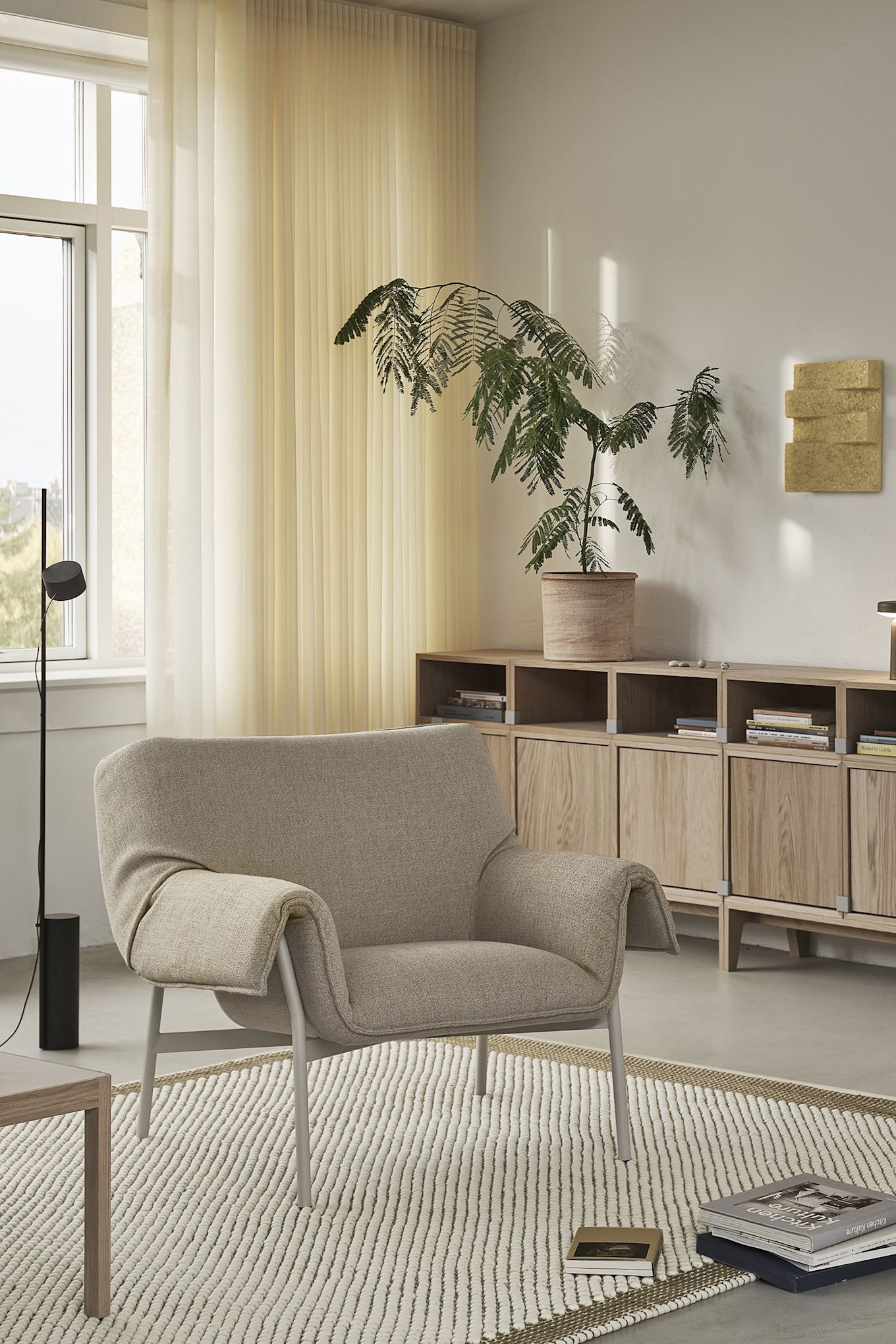 Le greige fait son retour dans les tendances de couleurs d'intérieur pour 2025, ici le fauteuil Wrap de Muuto dans une teinte gris-beige. 
