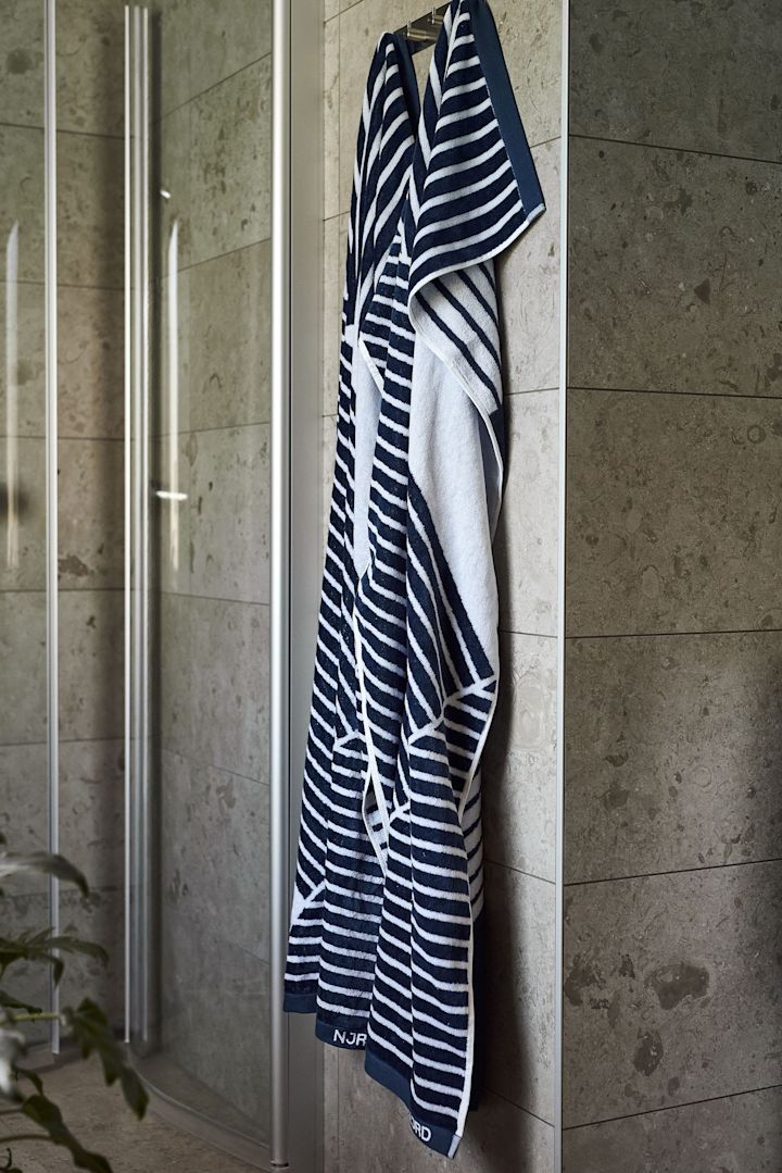Offrez le drap de bain Stripes de NJRD pour la fête des pères aux amateurs de sauna, suspendu ici devant une douche.