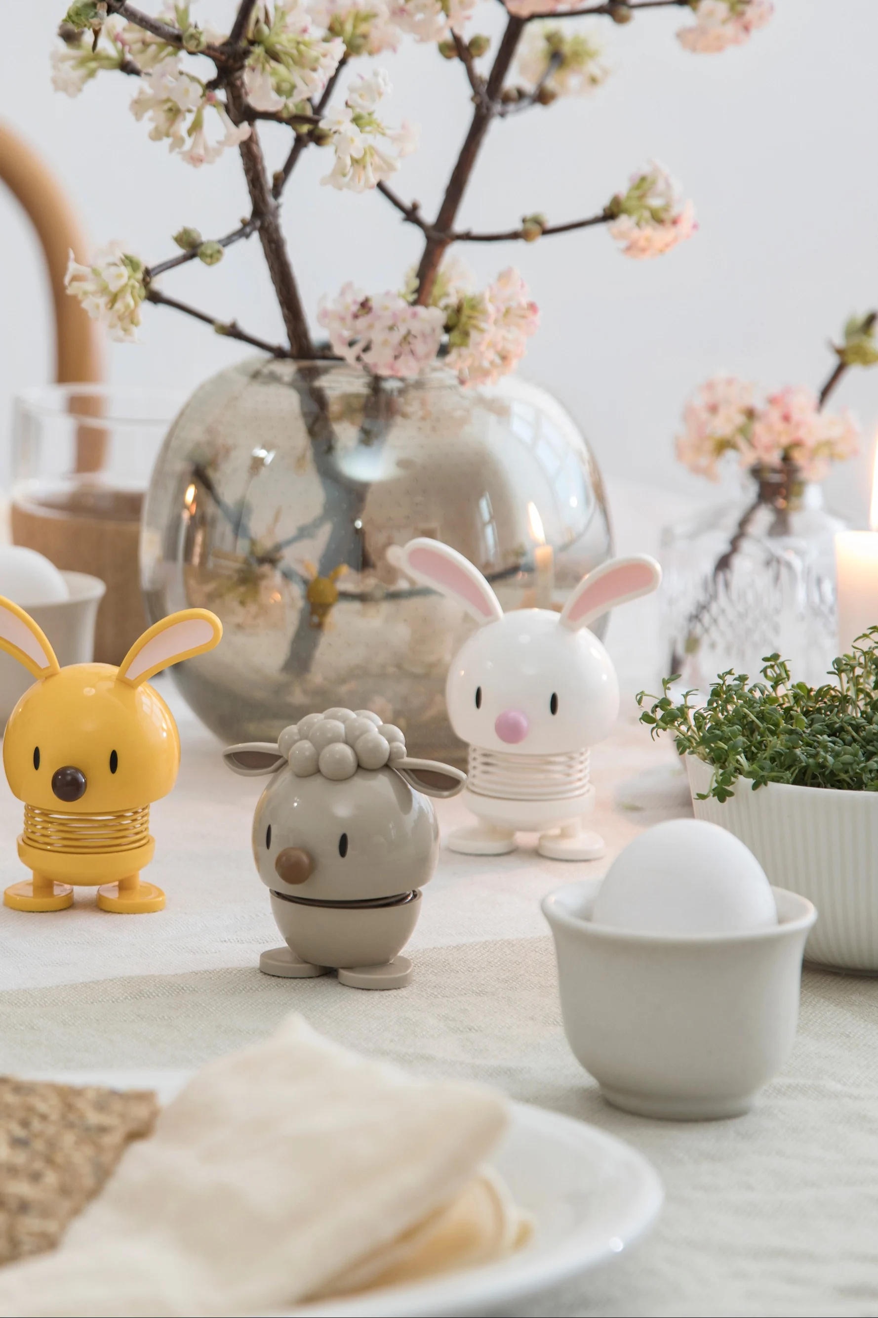 Les différentes figurines Hoptimist sont le cadeau idéal pour la Saint-Valentin pour les collectionneurs. Ici, les figurines lapin et agneau sont posées sur une table dressée.