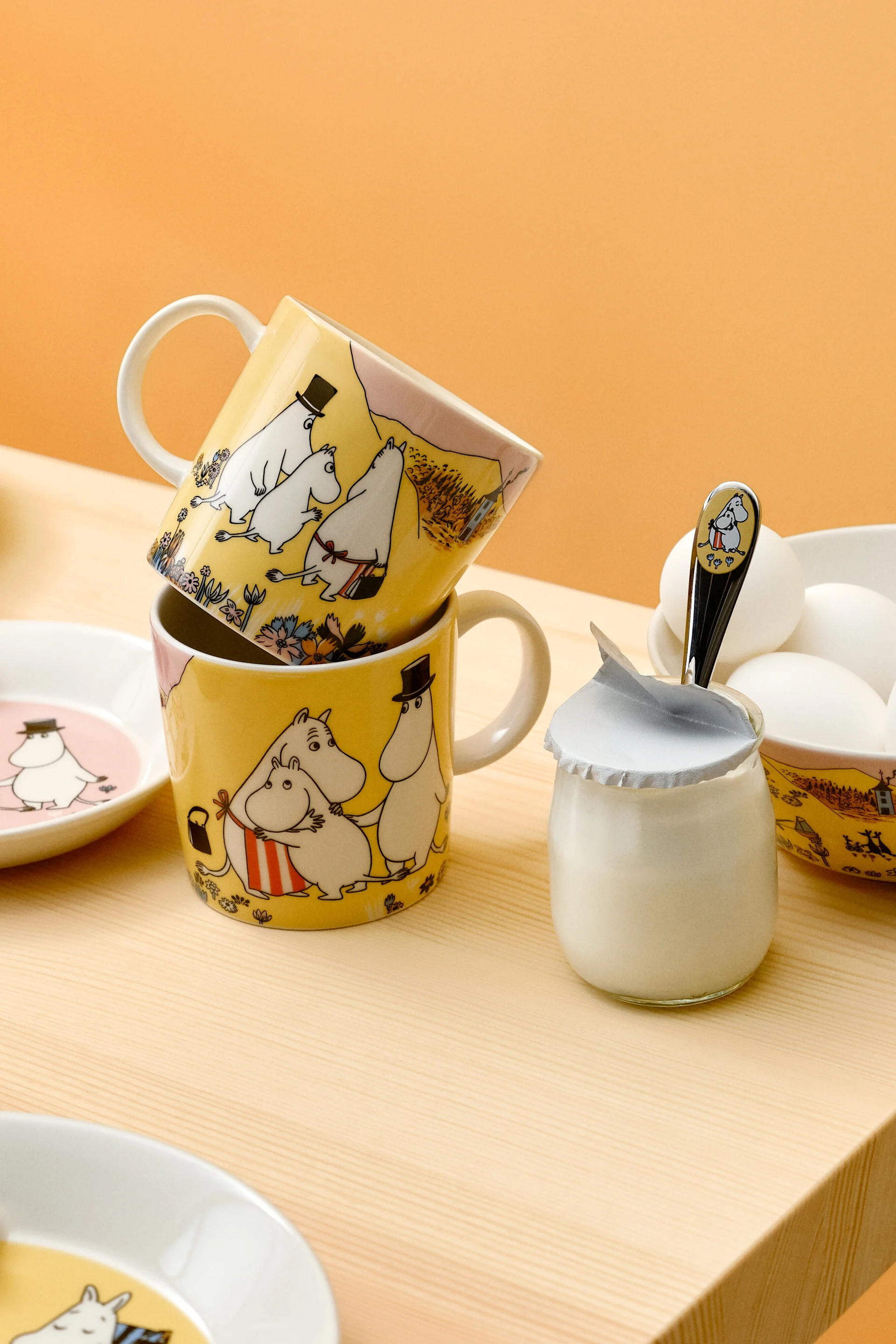 Deux tasses de Moomin sont empilées sur une table de petit-déjeuner.