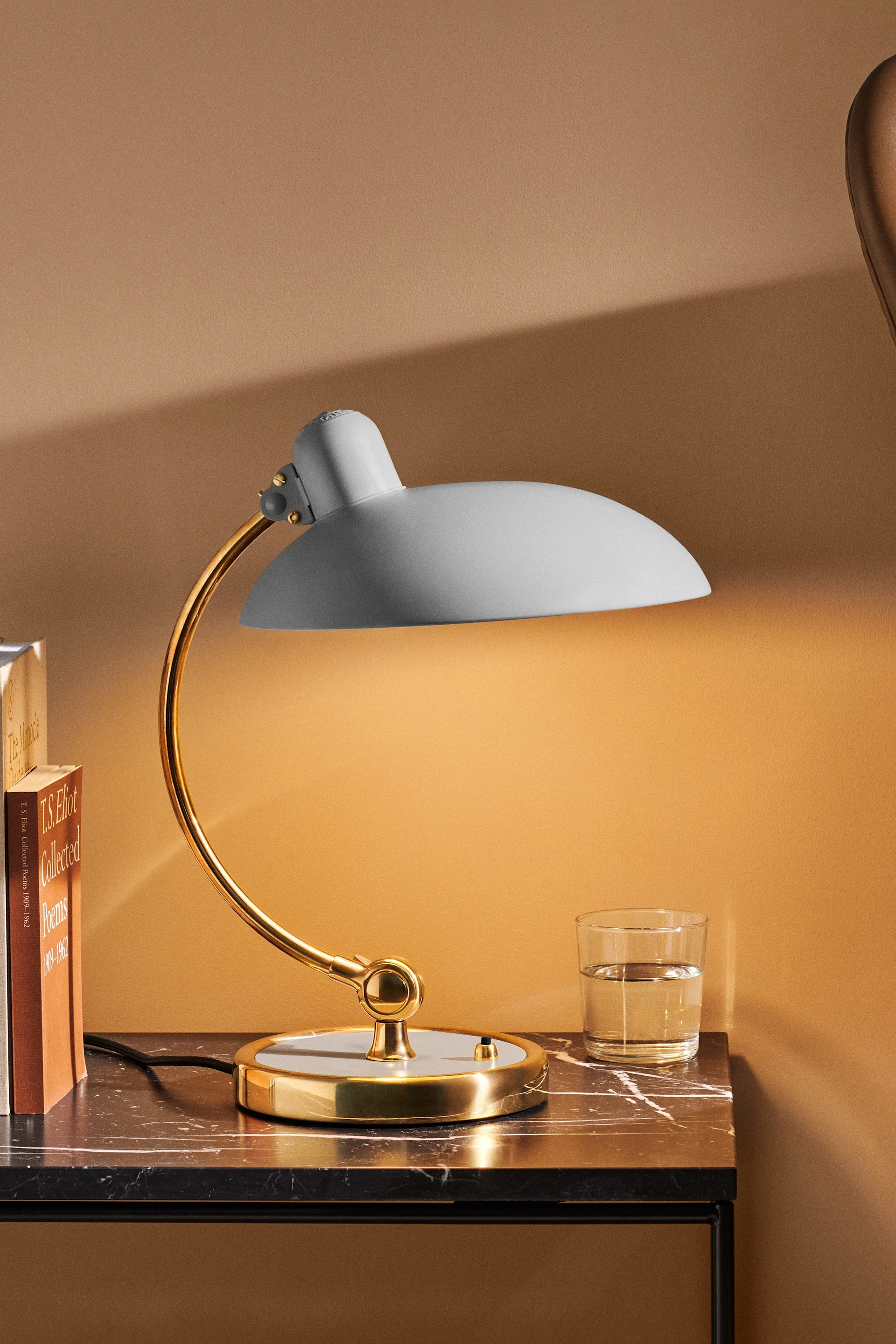 Lampes scandinaves : la lampe de chevet grise Kaiser Idell de Fritz Hansen trône sur une table de nuit.
