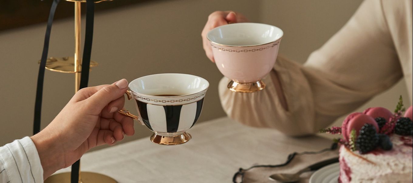 Célébrez la Journée de la Galentine en prenant le traditionnel thé de l'après-midi avec vos amies. Ici, deux amies prennent le thé dans des tasses de forme traditionnelle de Hilke. 