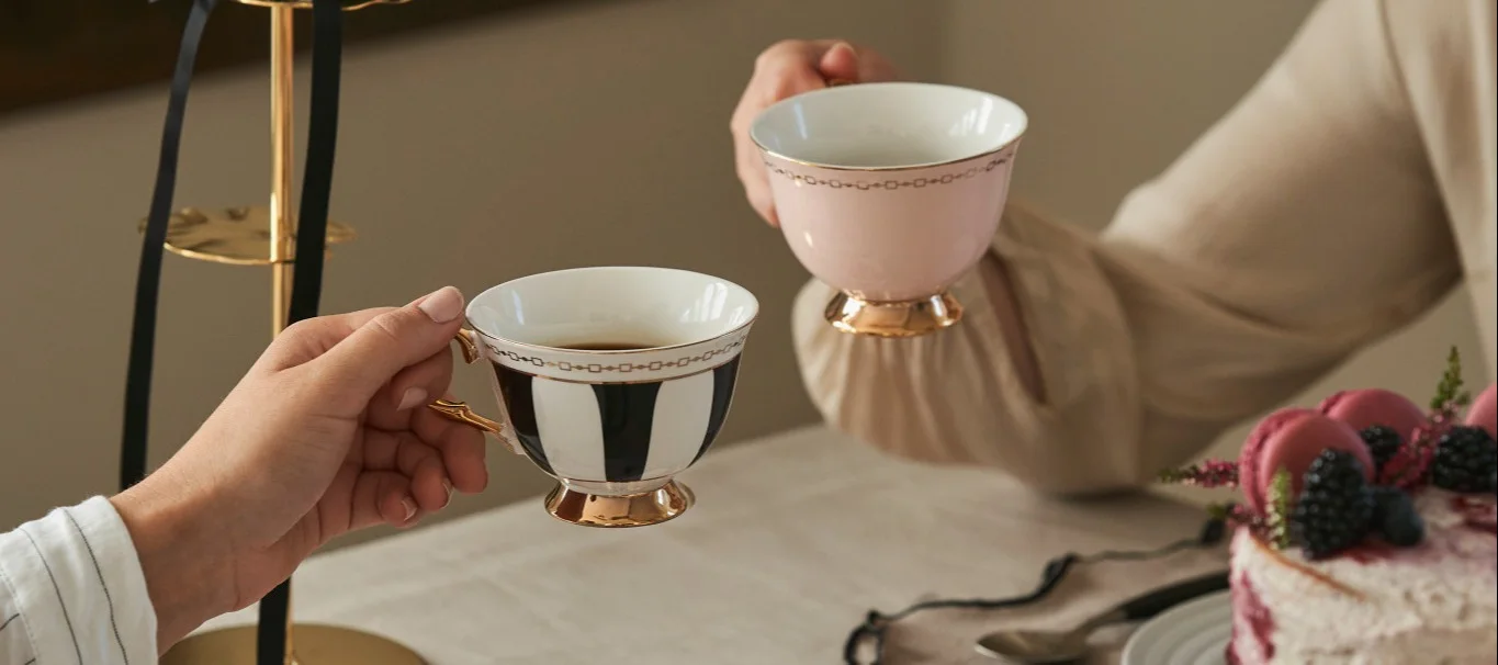 Célébrez la Journée de la Galentine en prenant le traditionnel thé de l'après-midi avec vos amies. Ici, deux amies prennent le thé dans des tasses de forme traditionnelle de Hilke.