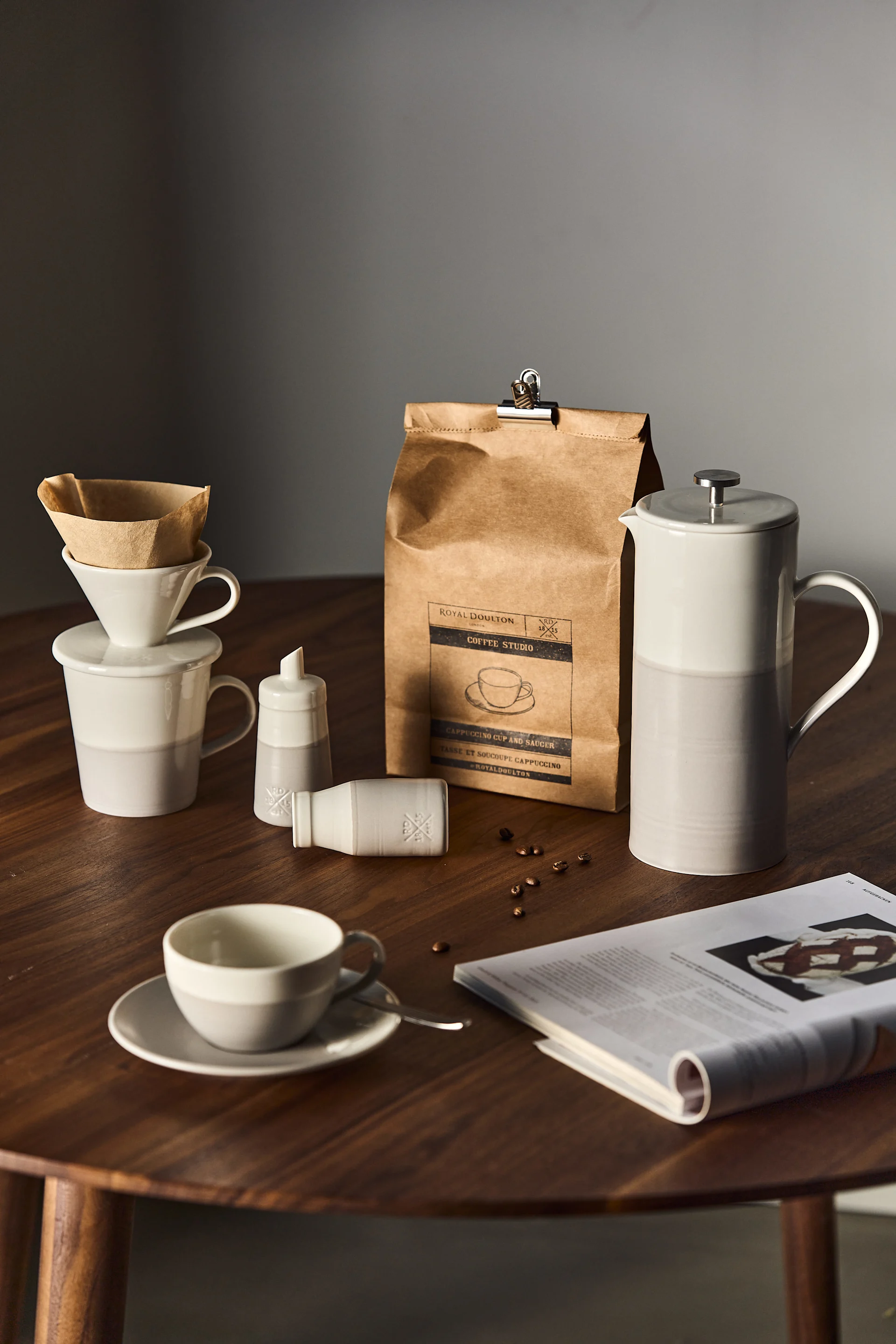 Les accessoires pour le café ou le thé sont un cadeau idéal pour la Saint-Valentin. Ici, une cafetière, une cafetière à piston et une tasse de la collection Coffee Studio de Royal Doulton sont disposées sur une table.